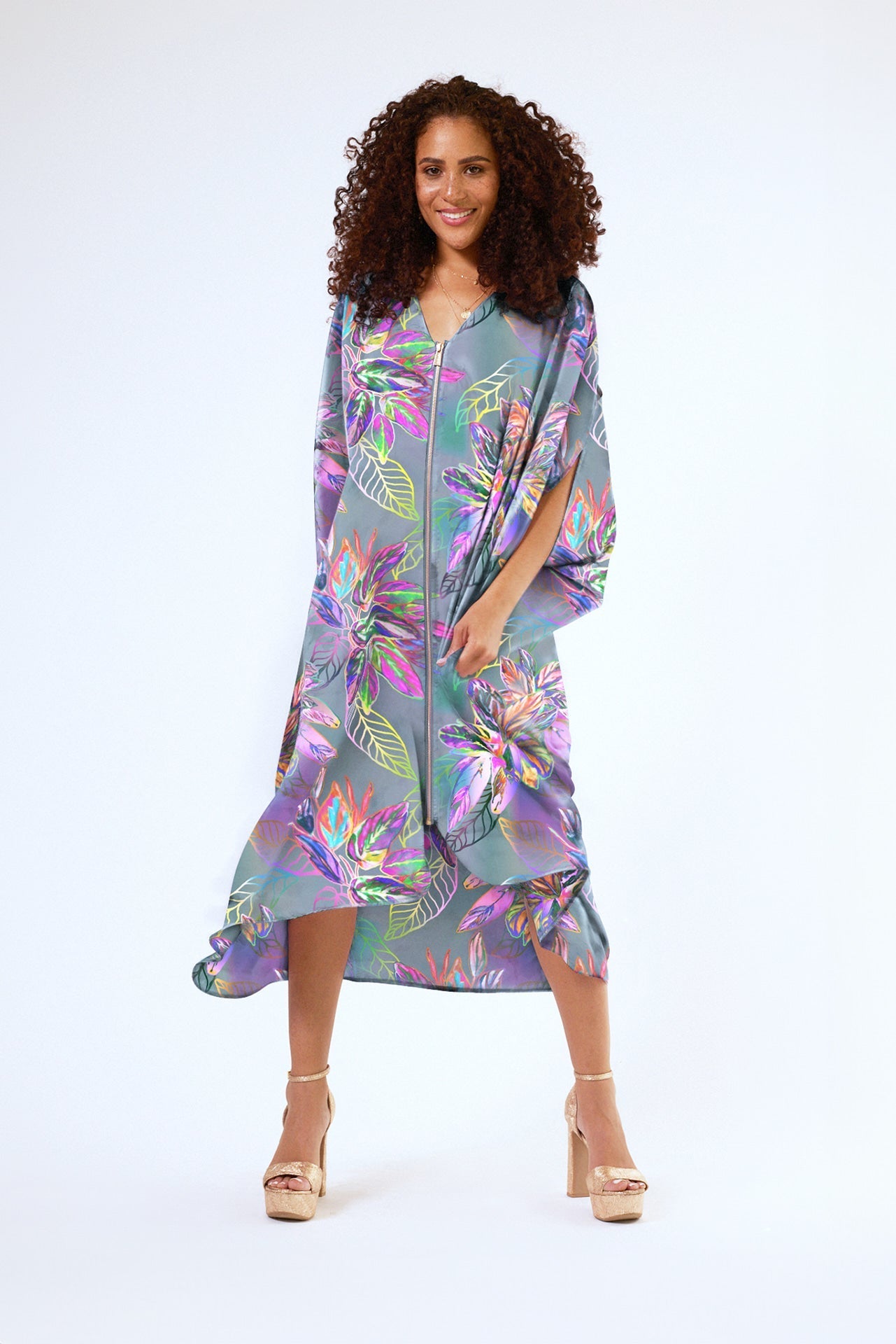 front view of woman wearing all over tropical print kaftan duster with front zipper made from recycled materials