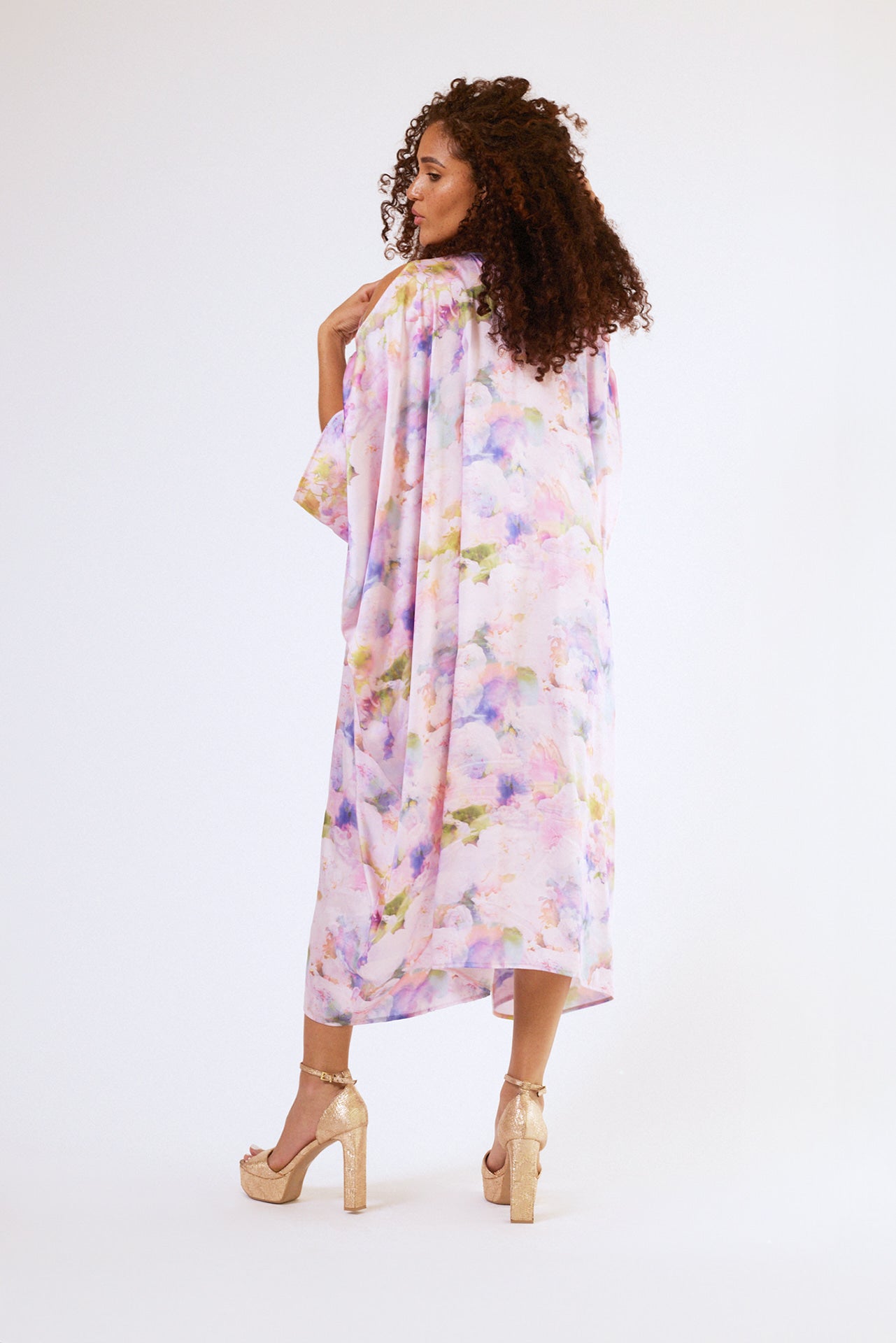 back profile of woman modelling pink floral kaftan duster with front zipper made from recycled textiles 3