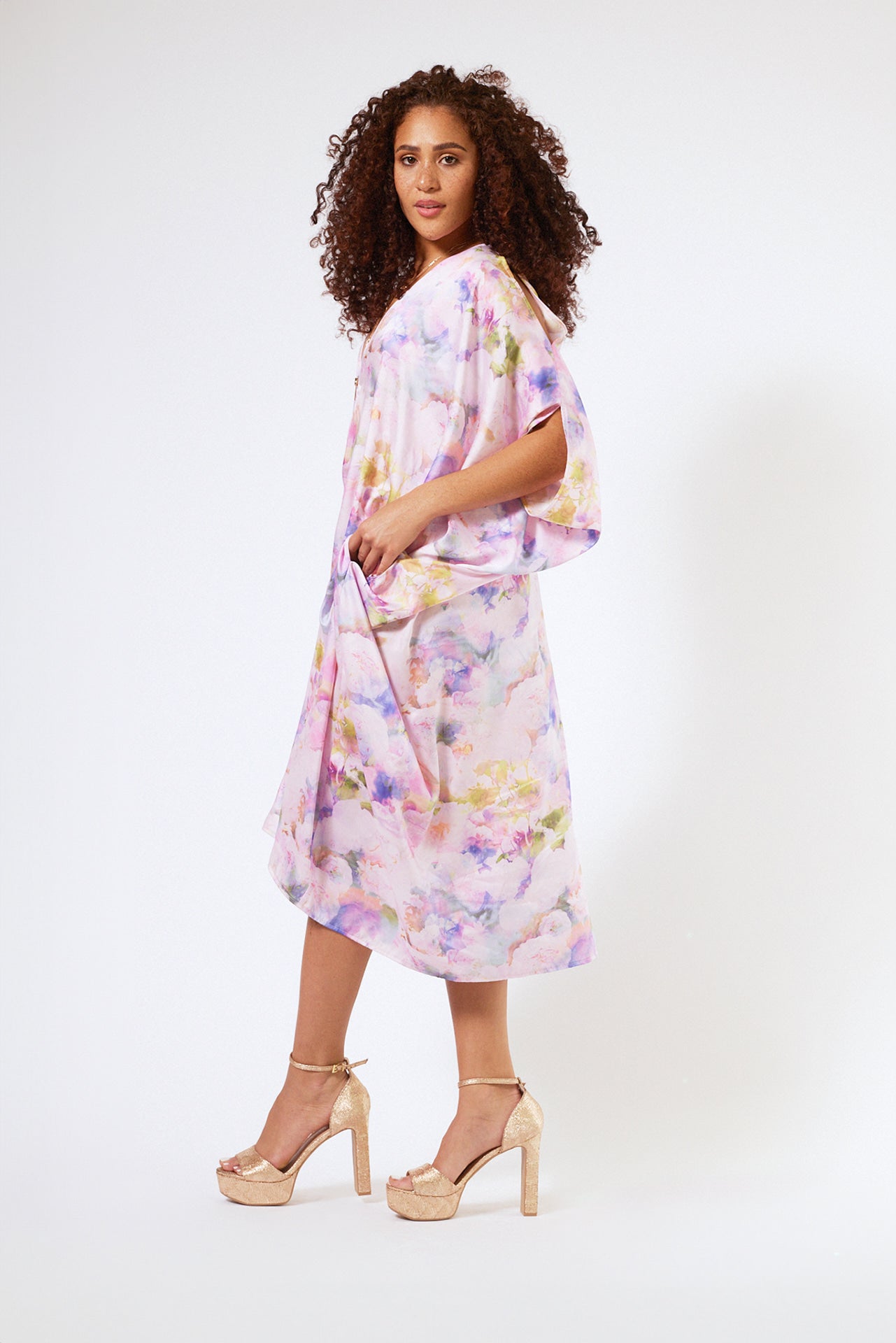 side profile view of woman wearing pink floral kaftan duster with zipper made from recycled materials 2