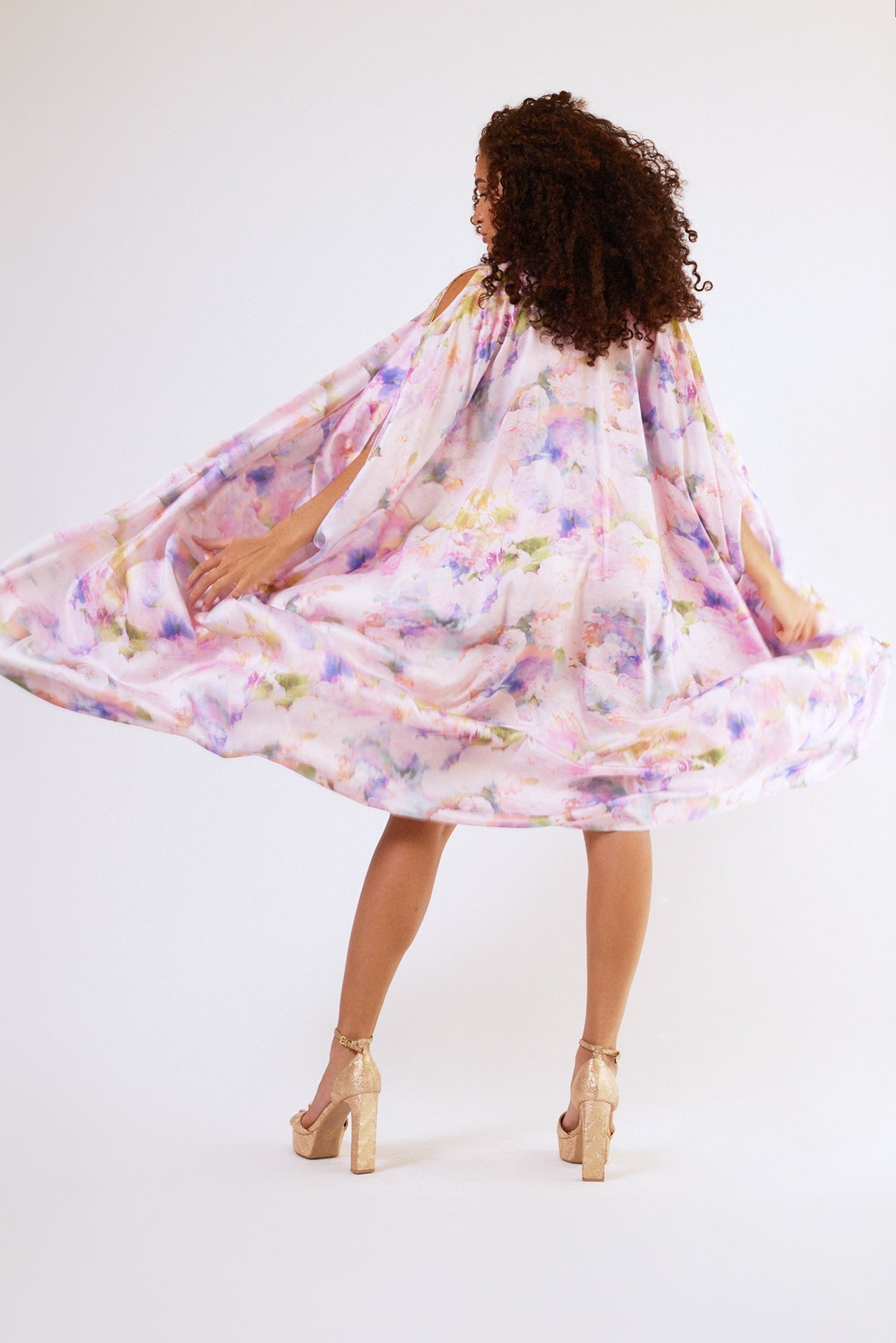 back profile of woman modelling pink floral kaftan duster with front zipper made from recycled textiles
