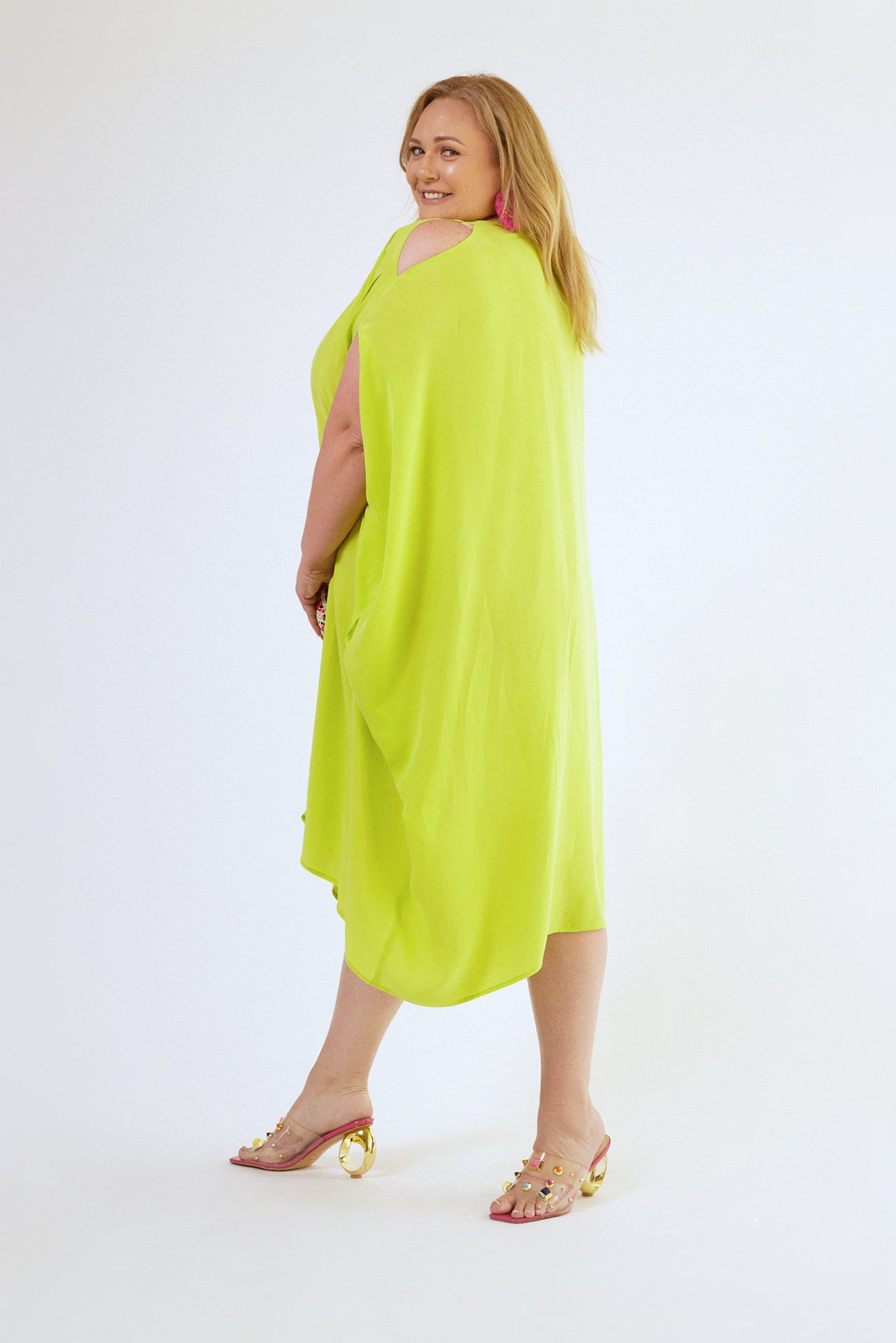 back view of woman wearing bright yellow kaftan duster with front zipper made from recycled materials 5