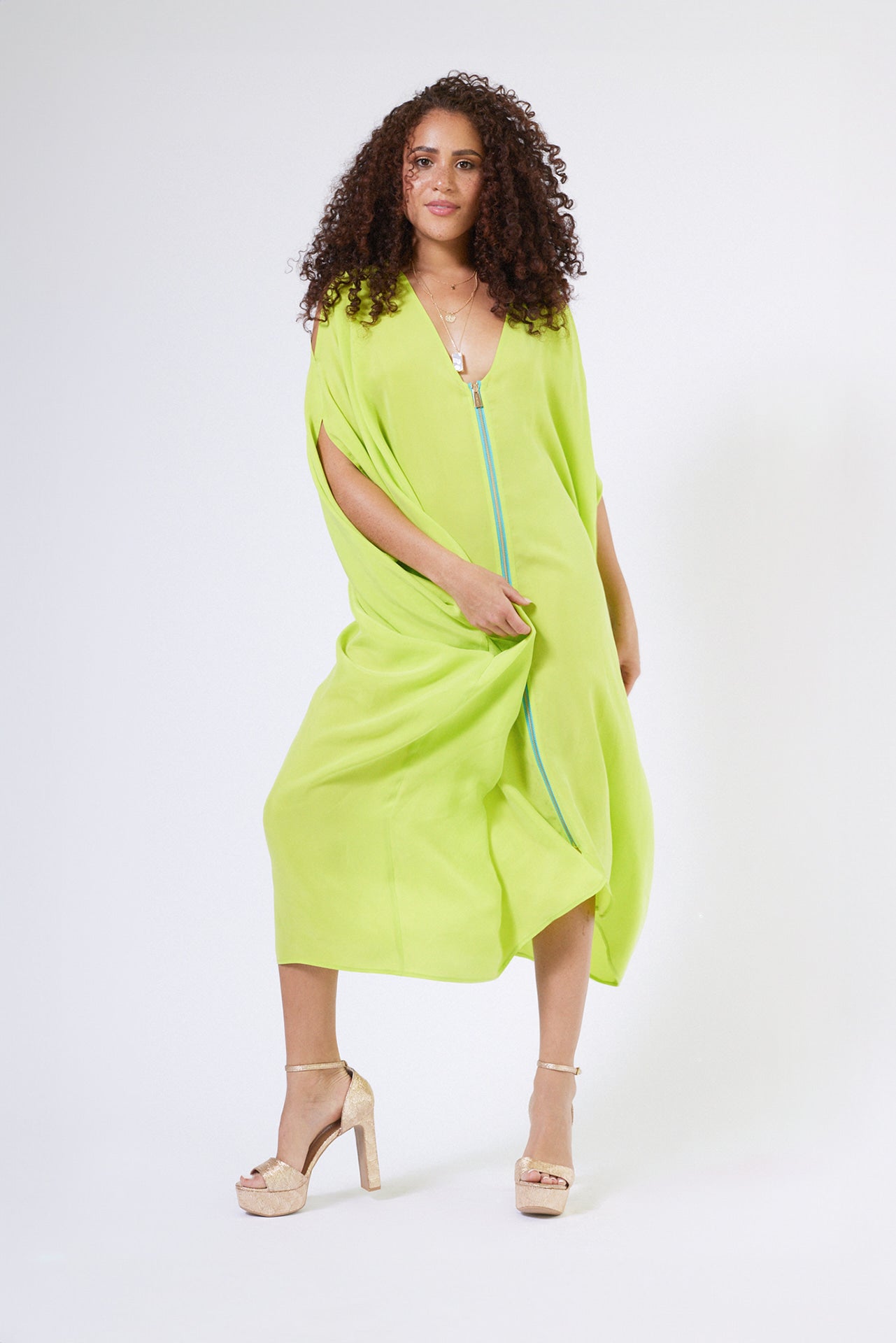 front view of woman wearing bright yellow kaftan duster with front zipper made from recycled materials 2