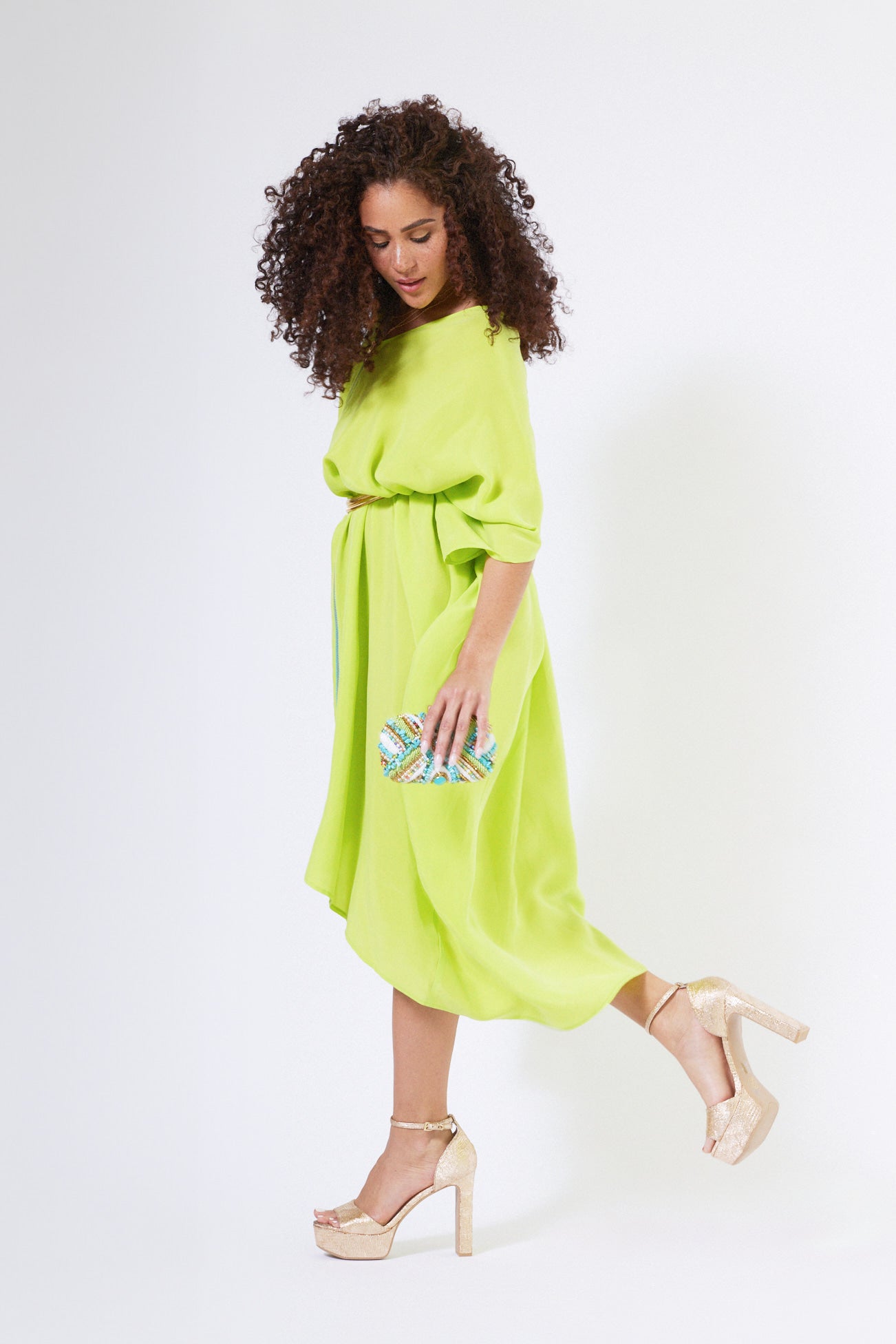 side view of woman wearing bright yellow kaftan duster with front zipper made from recycled materials