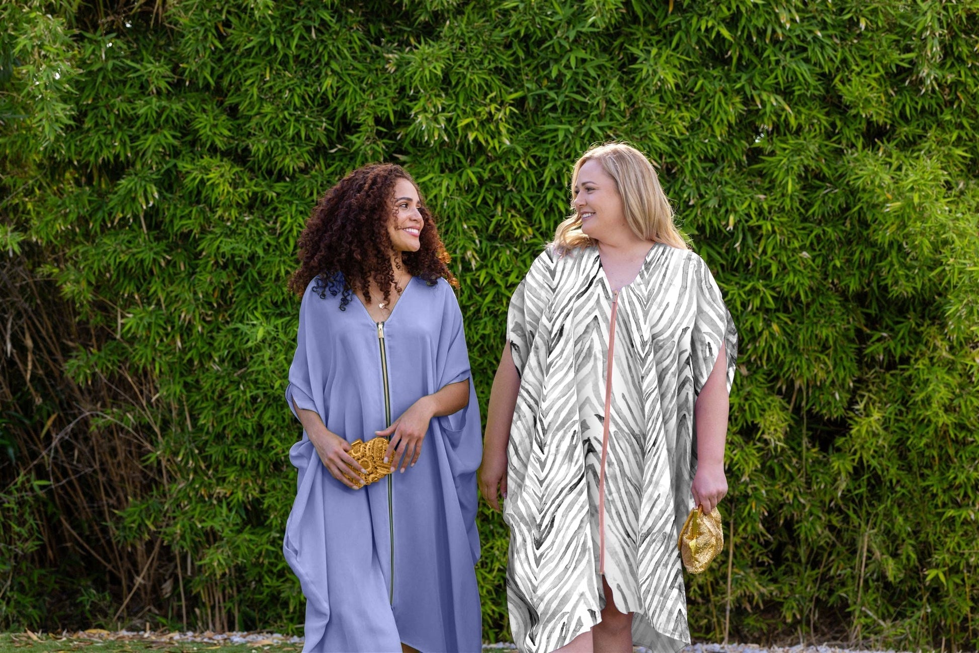 two women outside wearing zebra print and lavender haze kaftan dusters with front zipper made from recycled materials