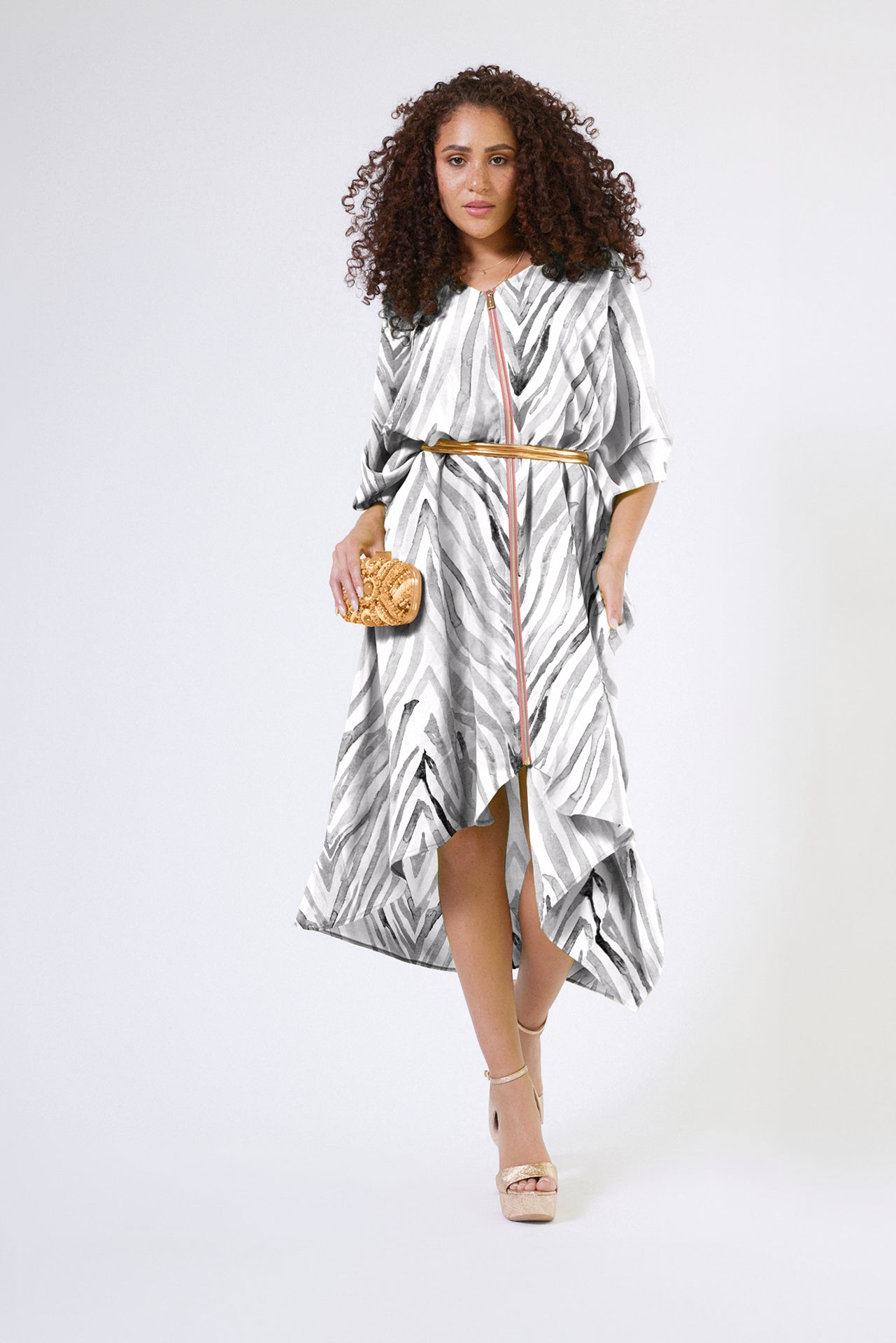front profile of woman wearing an all over grey and white zebra print kaftan duster with zipper made from recycled materials 3