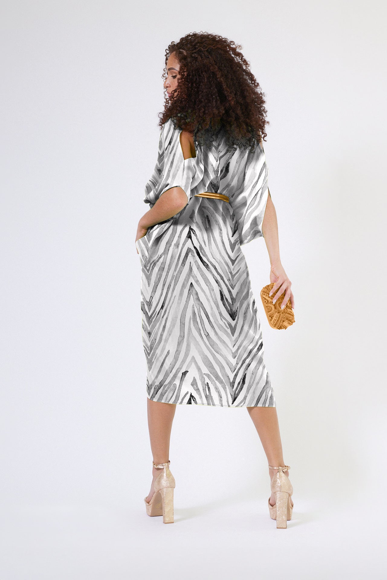 side profile of woman wearing an all over grey and white zebra print kaftan duster with zipper made from recycled materials