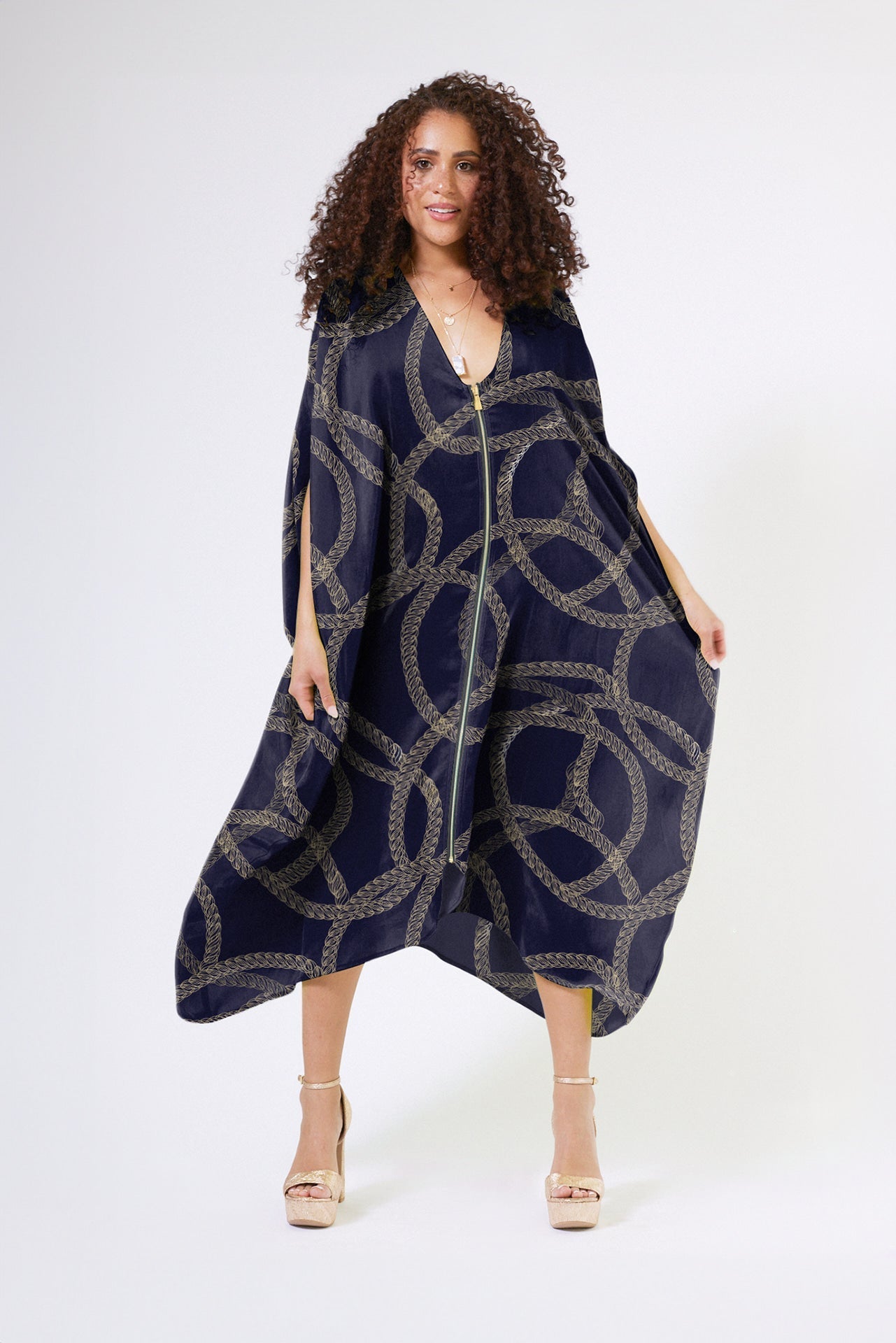 front view of woman modelling gold and black chain printed kaftan duster with front zipper made from recycled materials
