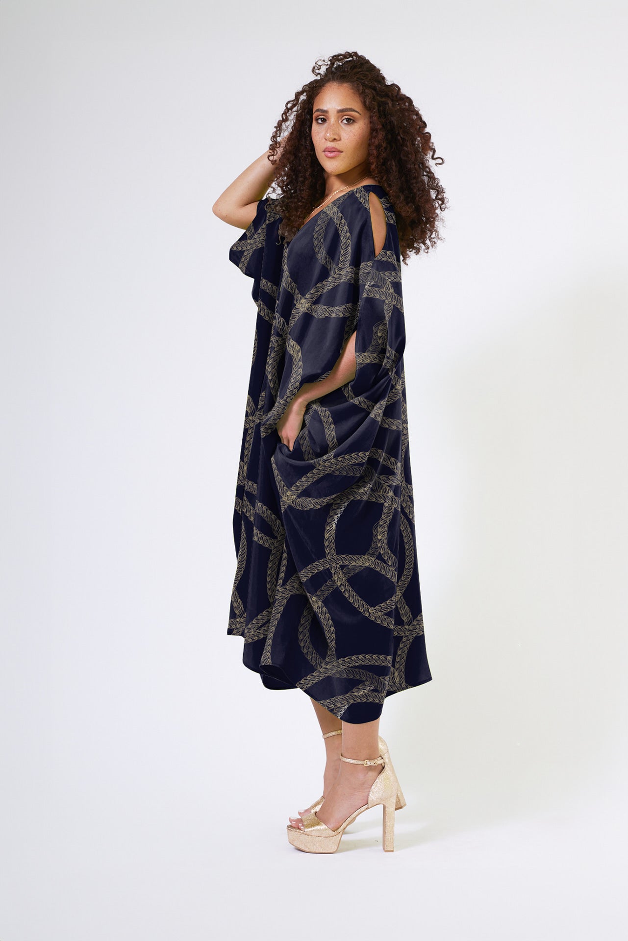 front view of woman modelling gold and black chain printed kaftan duster with front zipper made from recycled materials 2