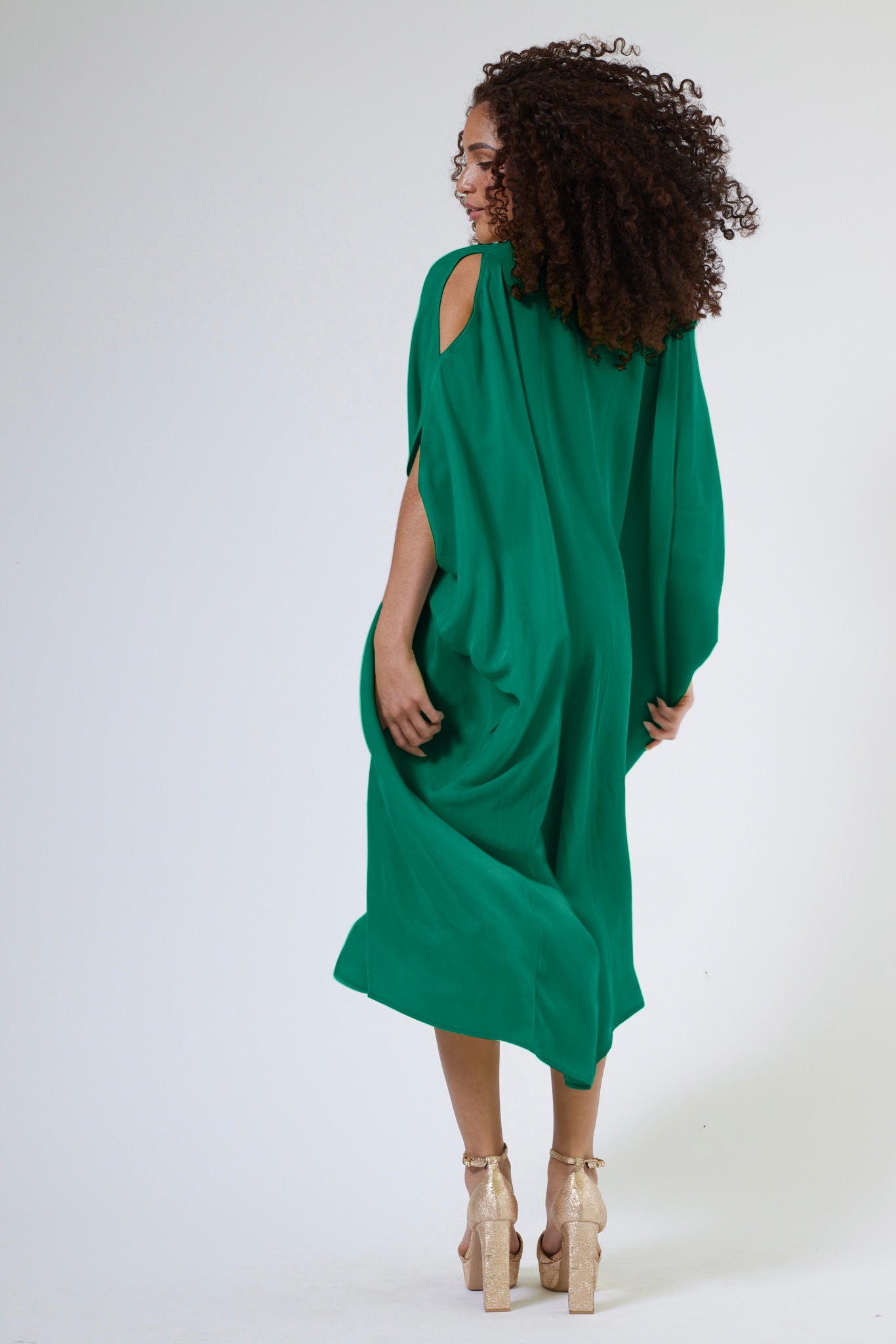 back profile view of woman wearing green kaftan duster with front zipper made from recycled materials