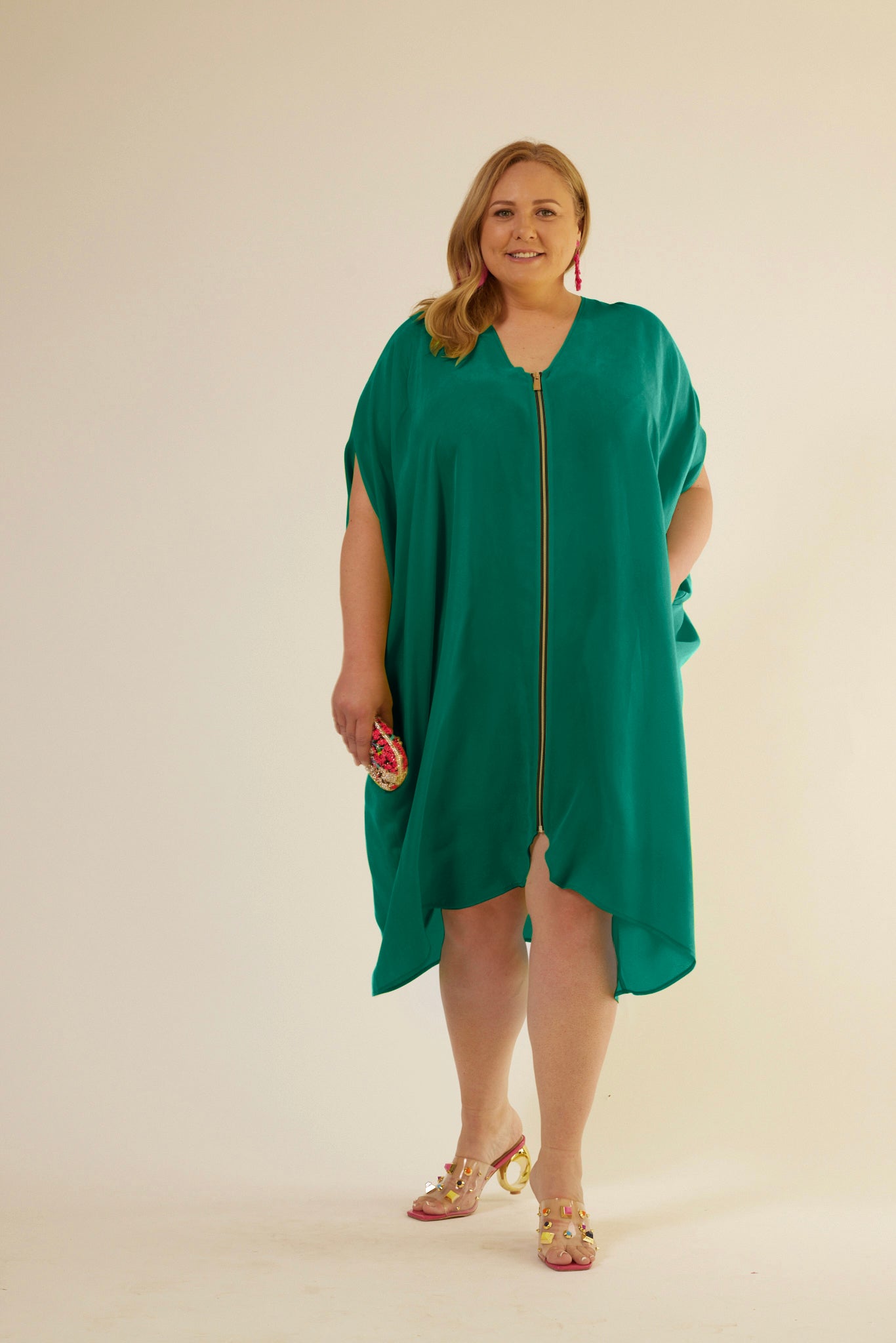 front profile view of woman wearing green kaftan duster with front zipper made from recycled materials 2