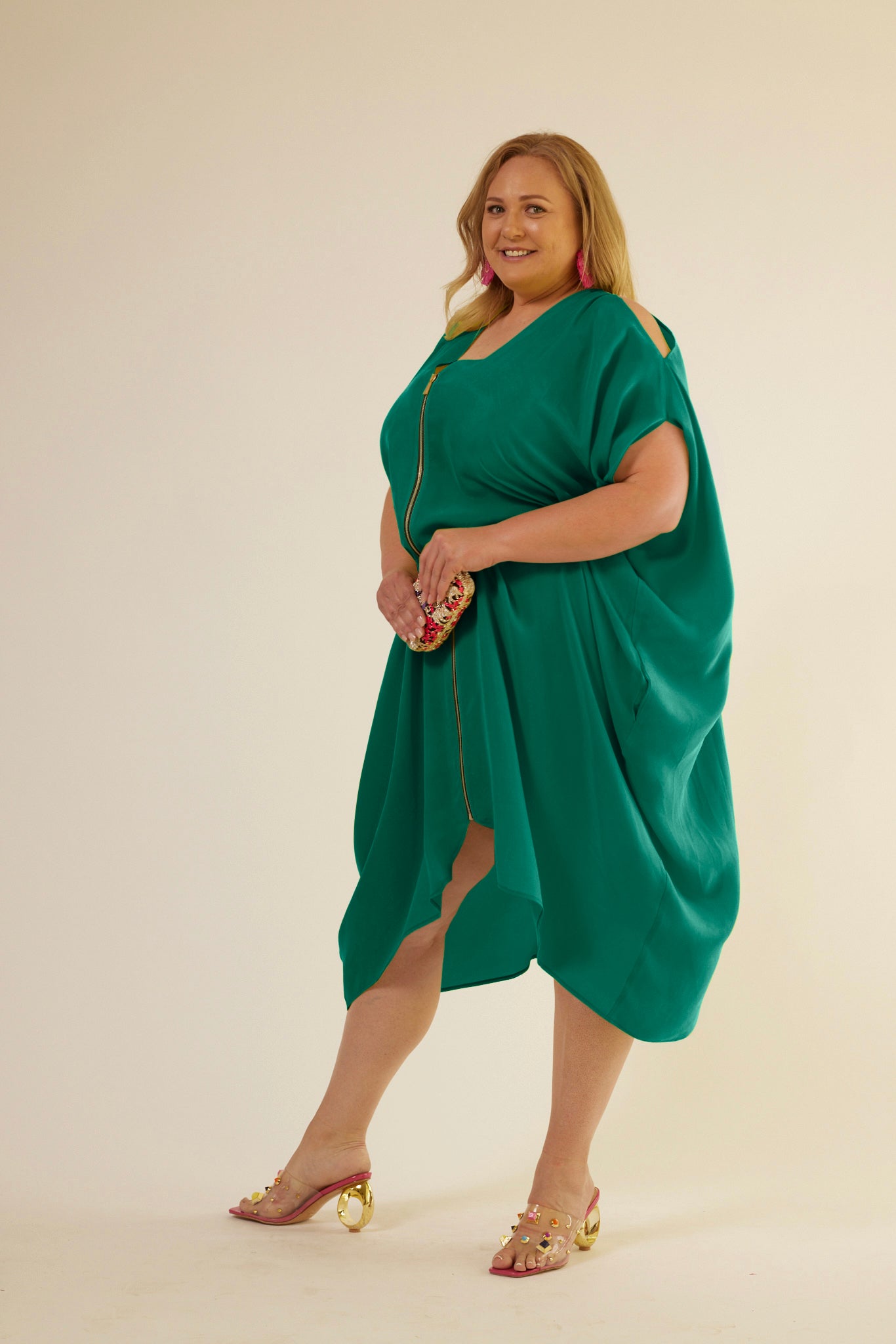 front profile view of woman wearing green kaftan duster with front zipper made from recycled materials 3