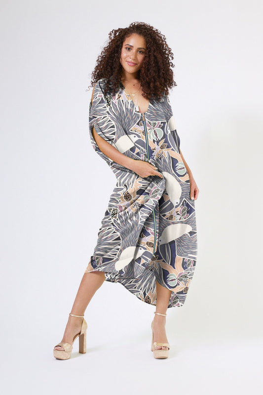 woman wearing navy and white toucan printed kaftan duster with front zipper made of recycled materials