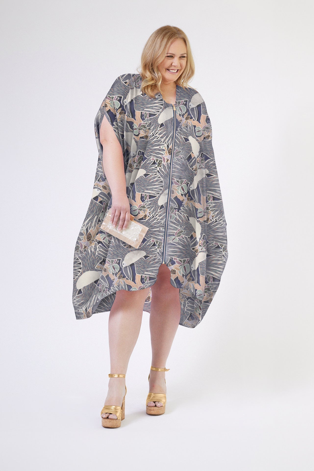 front profile of woman wearing grey yellow and white all over tropical print kaftan duster with zipper made from recycled materials 4