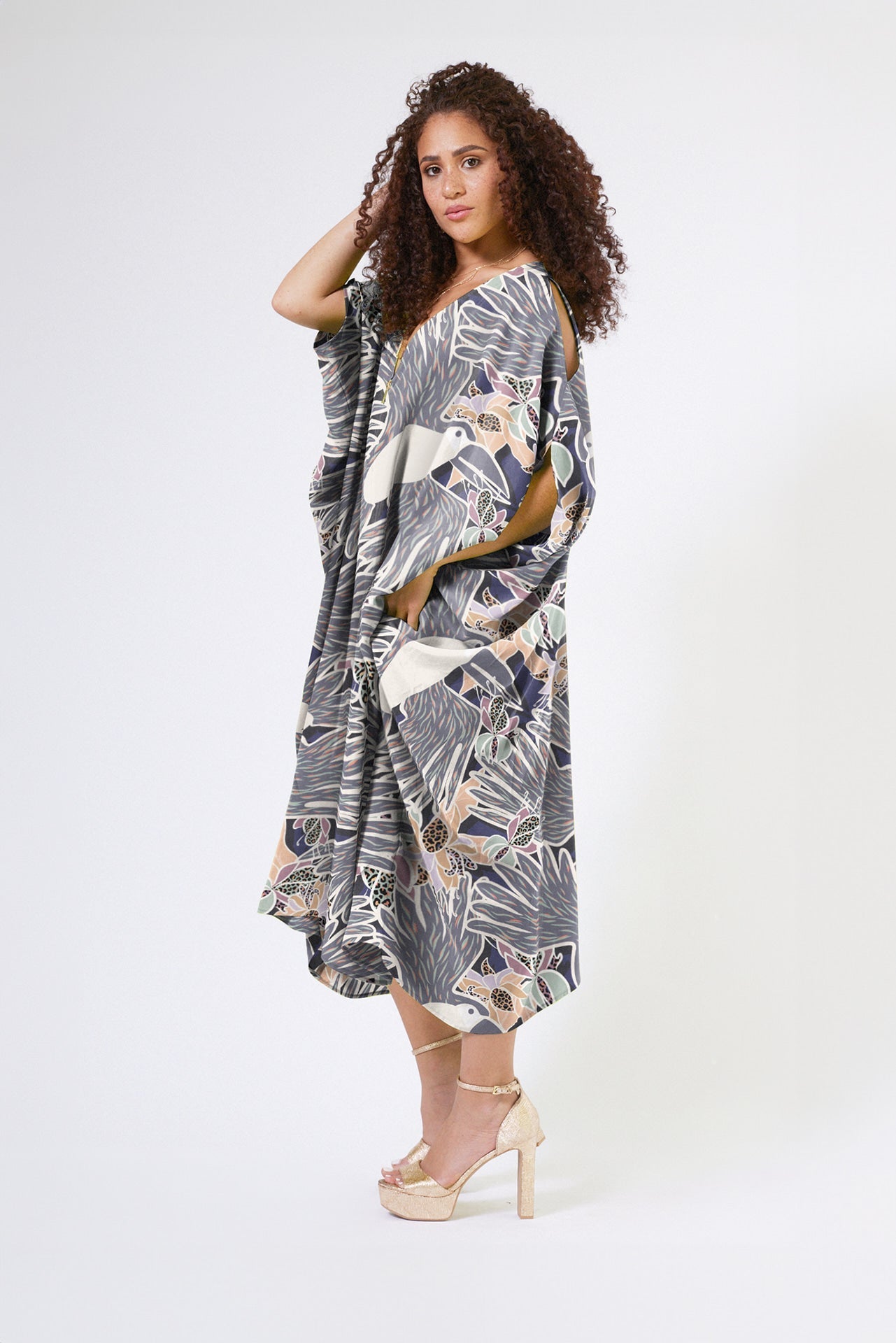 woman wearing navy and white toucan printed kaftan duster with front zipper made of recycled materials 2