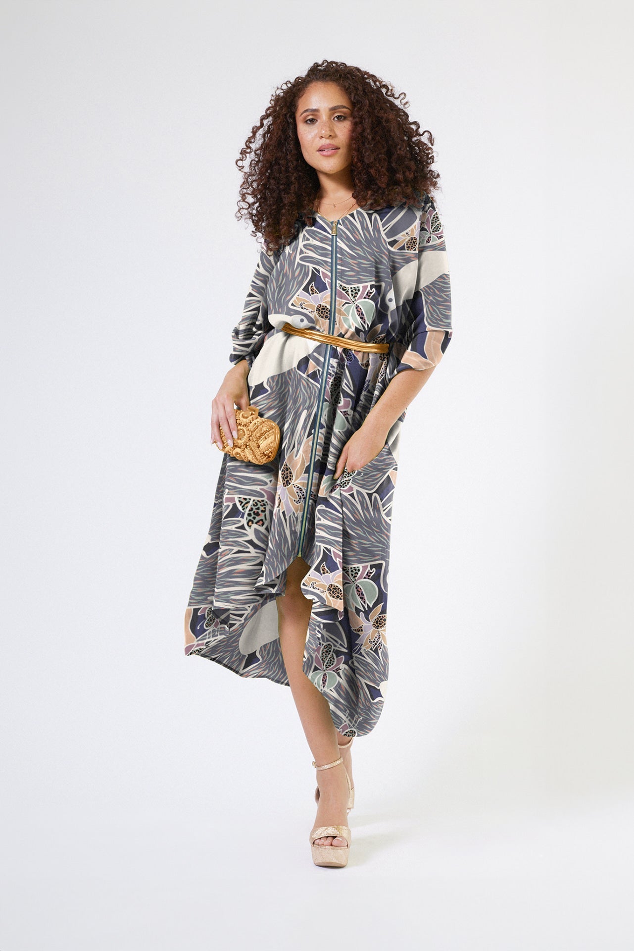 front profile of woman wearing navy and white toucan printed kaftan duster with front zipper made of recycled materials