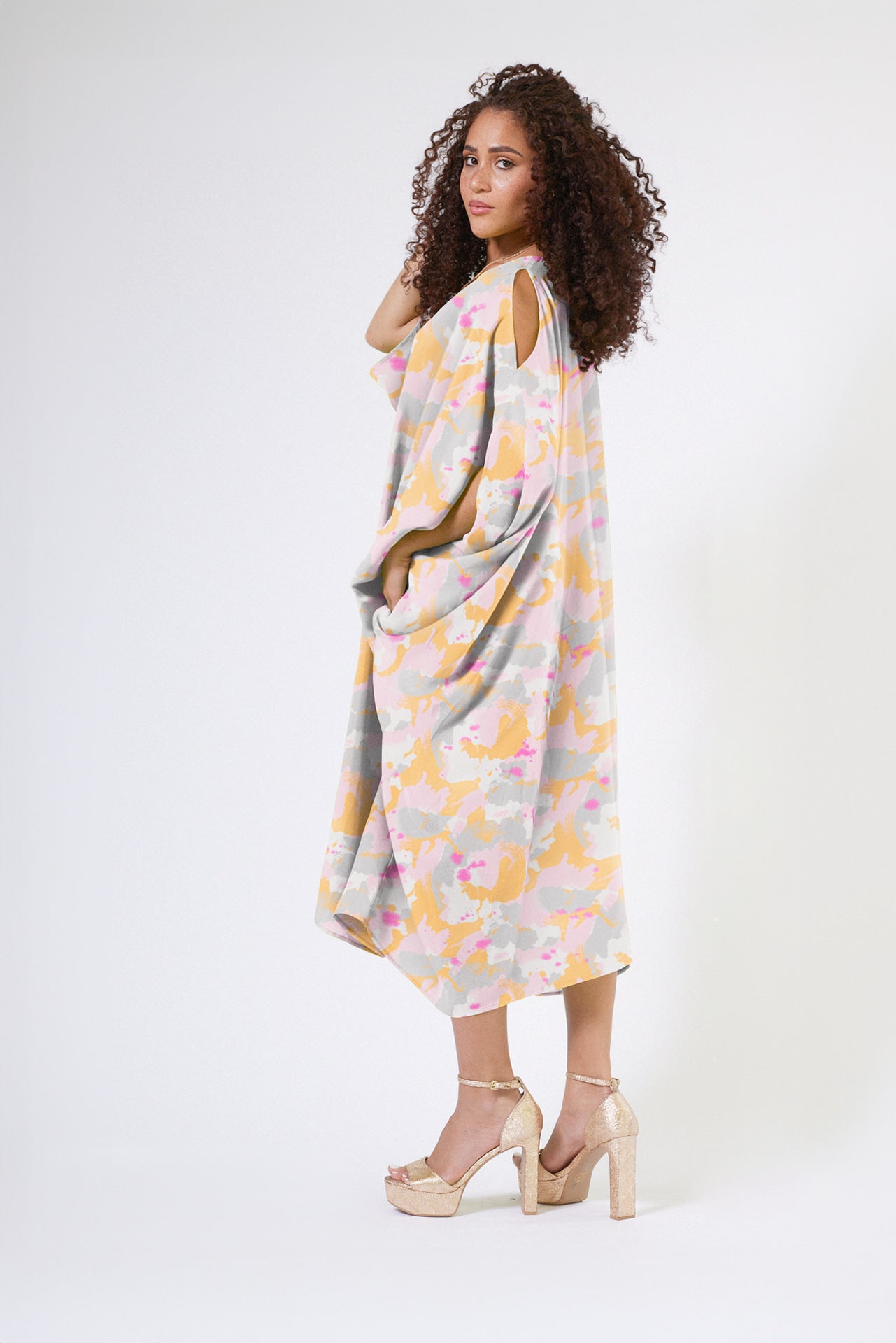 side view of woman modelling a pink army print kaftan duster with front zipper made from recycled materials 2