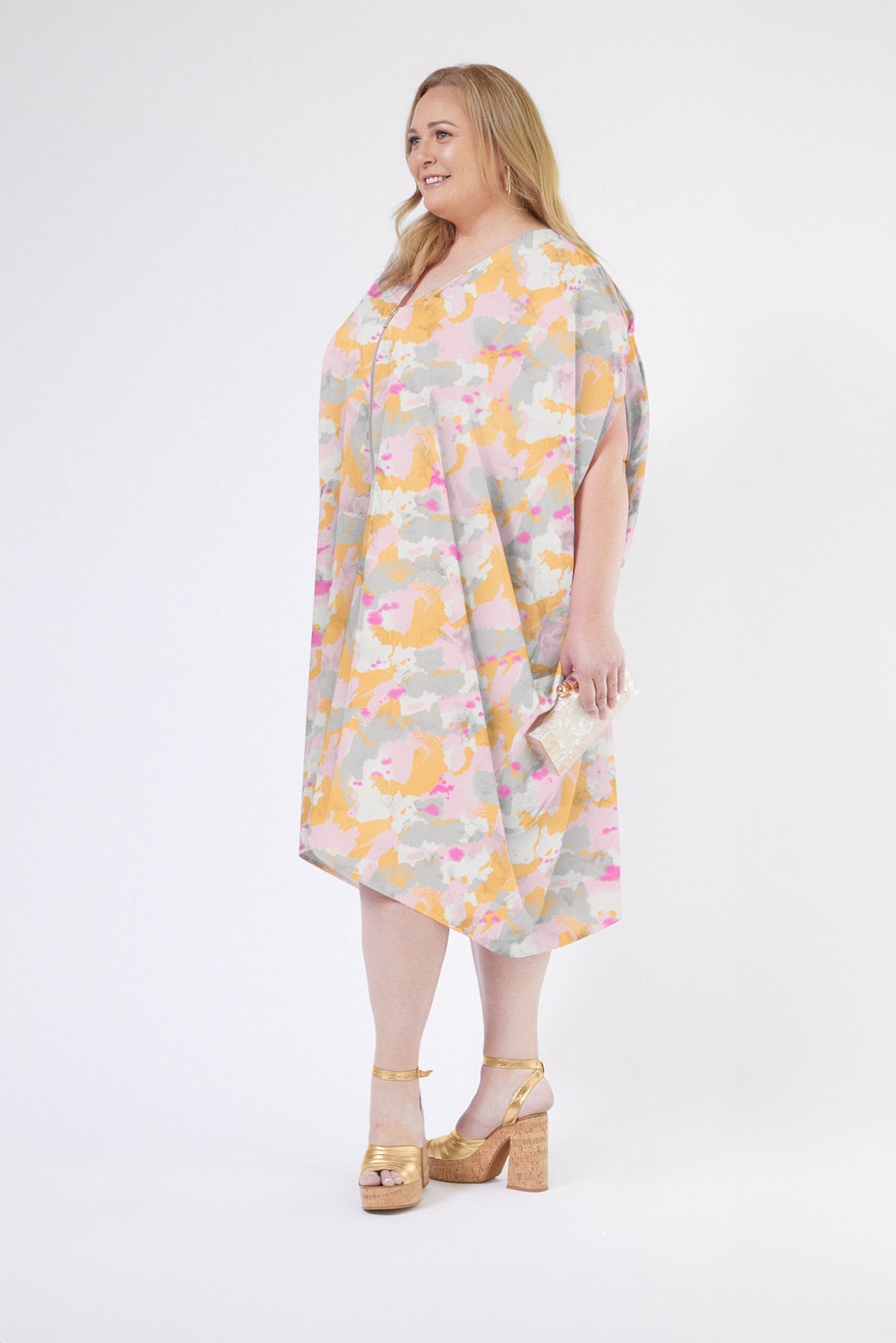 front profile view of woman modelling a pink army print kaftan duster with front zipper made from recycled materials 3