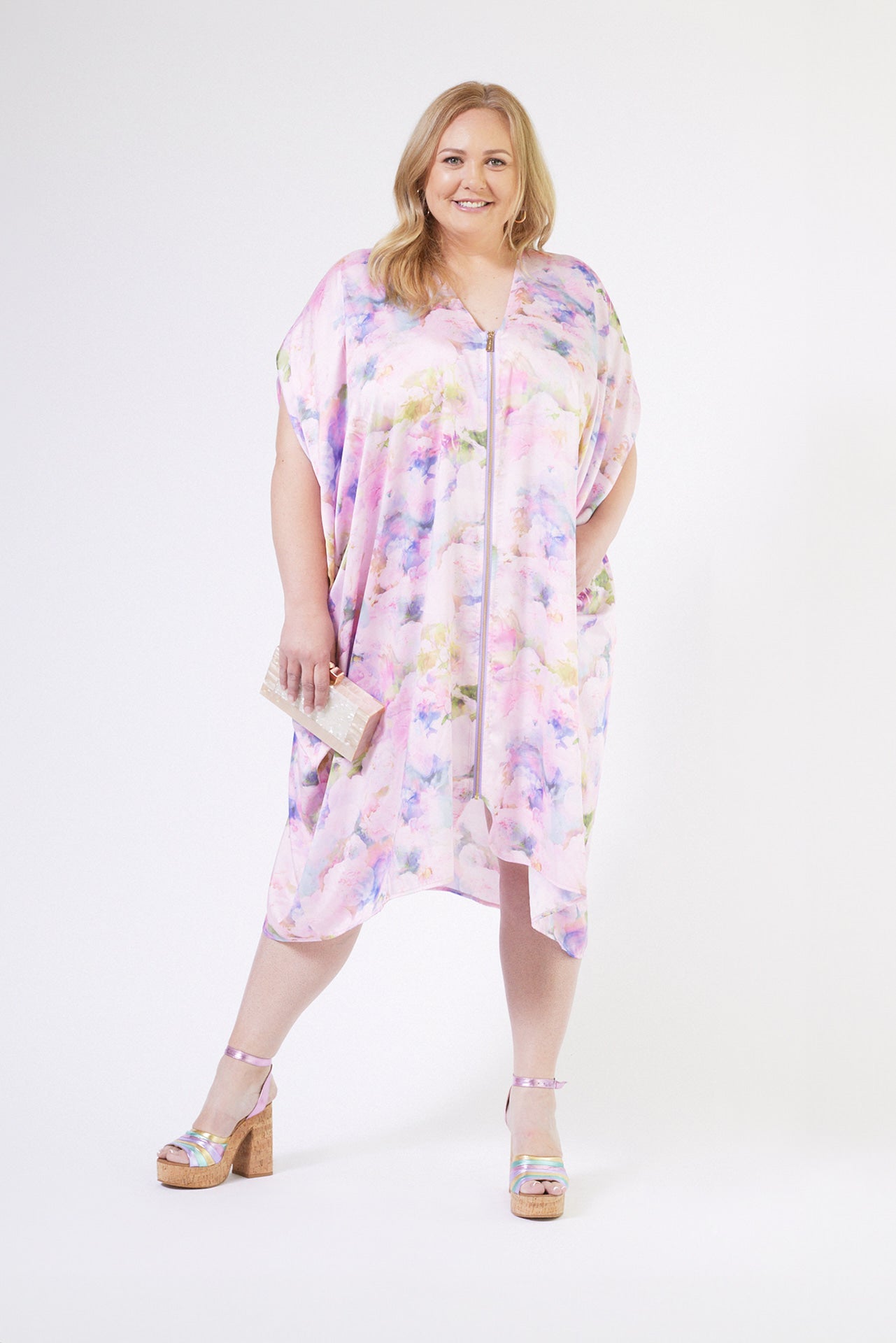 front profile of woman modelling pink floral kaftan duster with front zipper made from recycled textiles 4