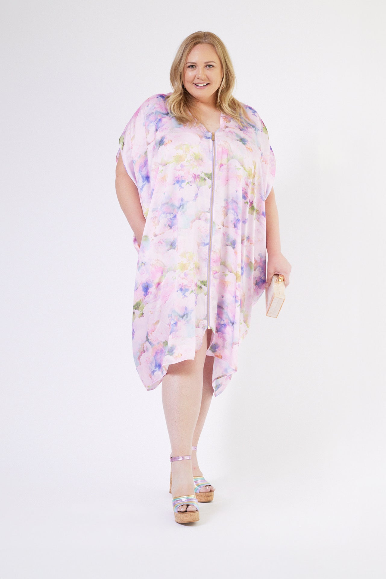 front profile of woman modelling pink floral kaftan duster with front zipper made from recycled textiles 6