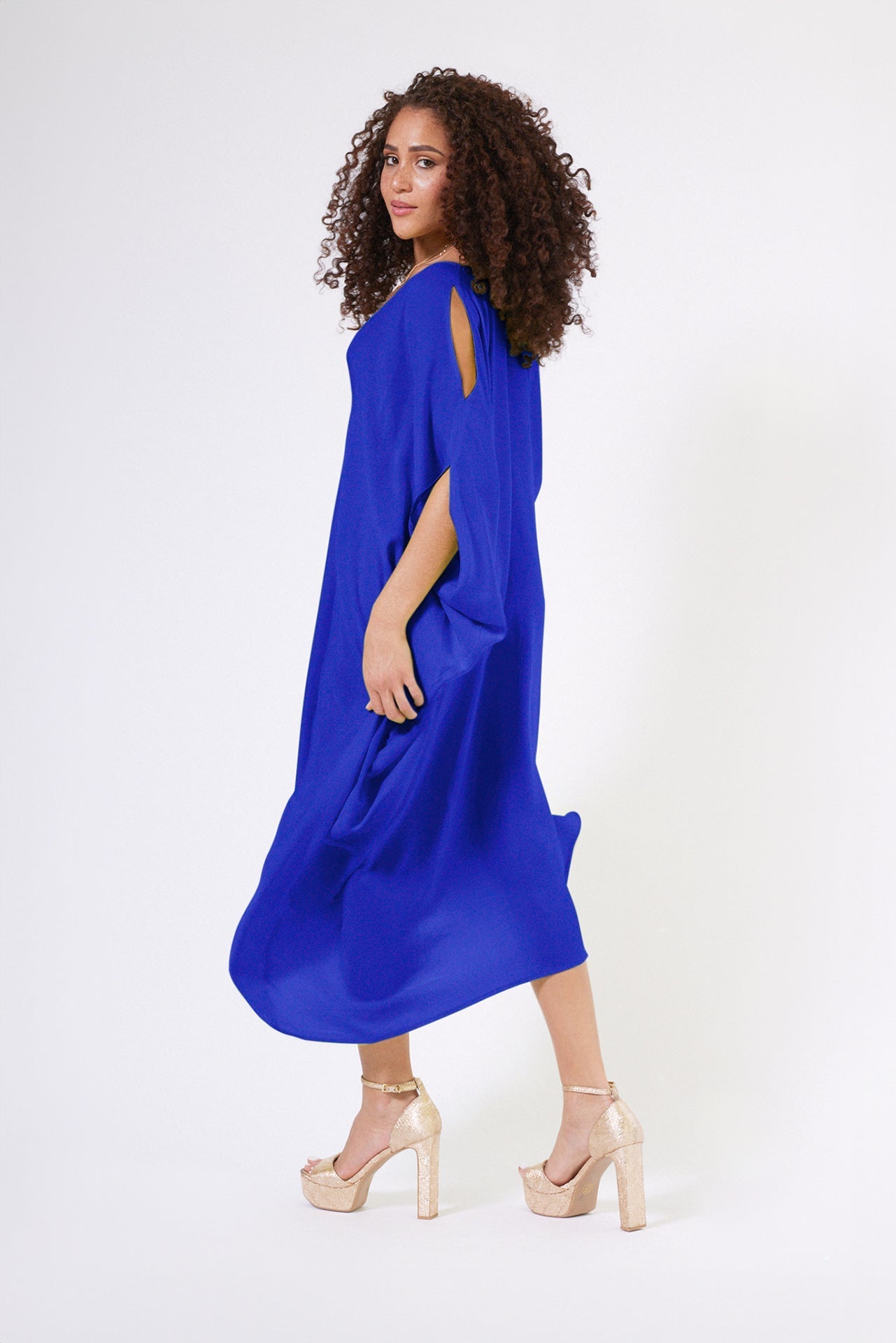 side profile view of woman wearing royal blue kaftan duster with front zipper made from recycled materials