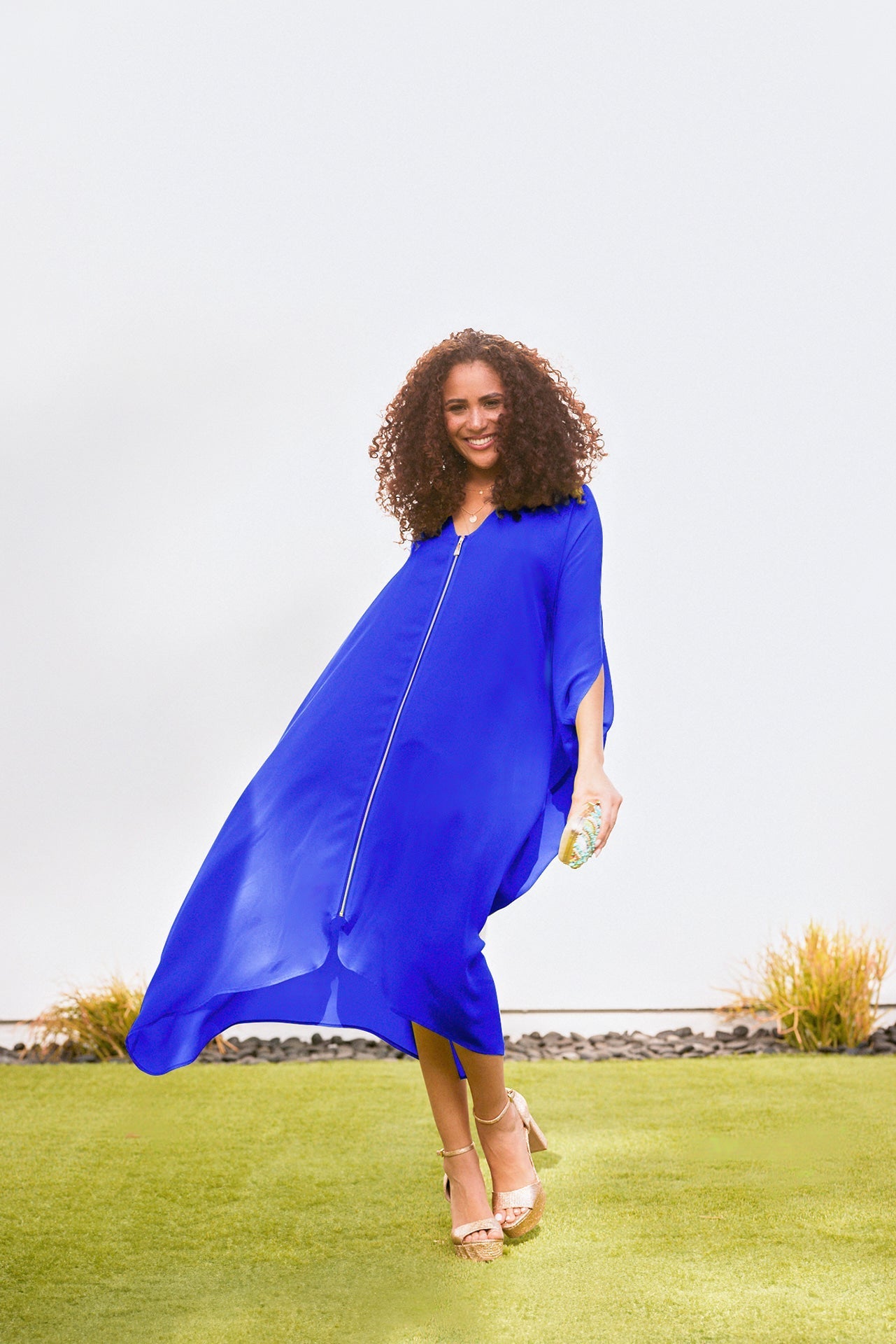 woman outside modelling a royal blue kaftan duster with front zipper made from recycled materials
