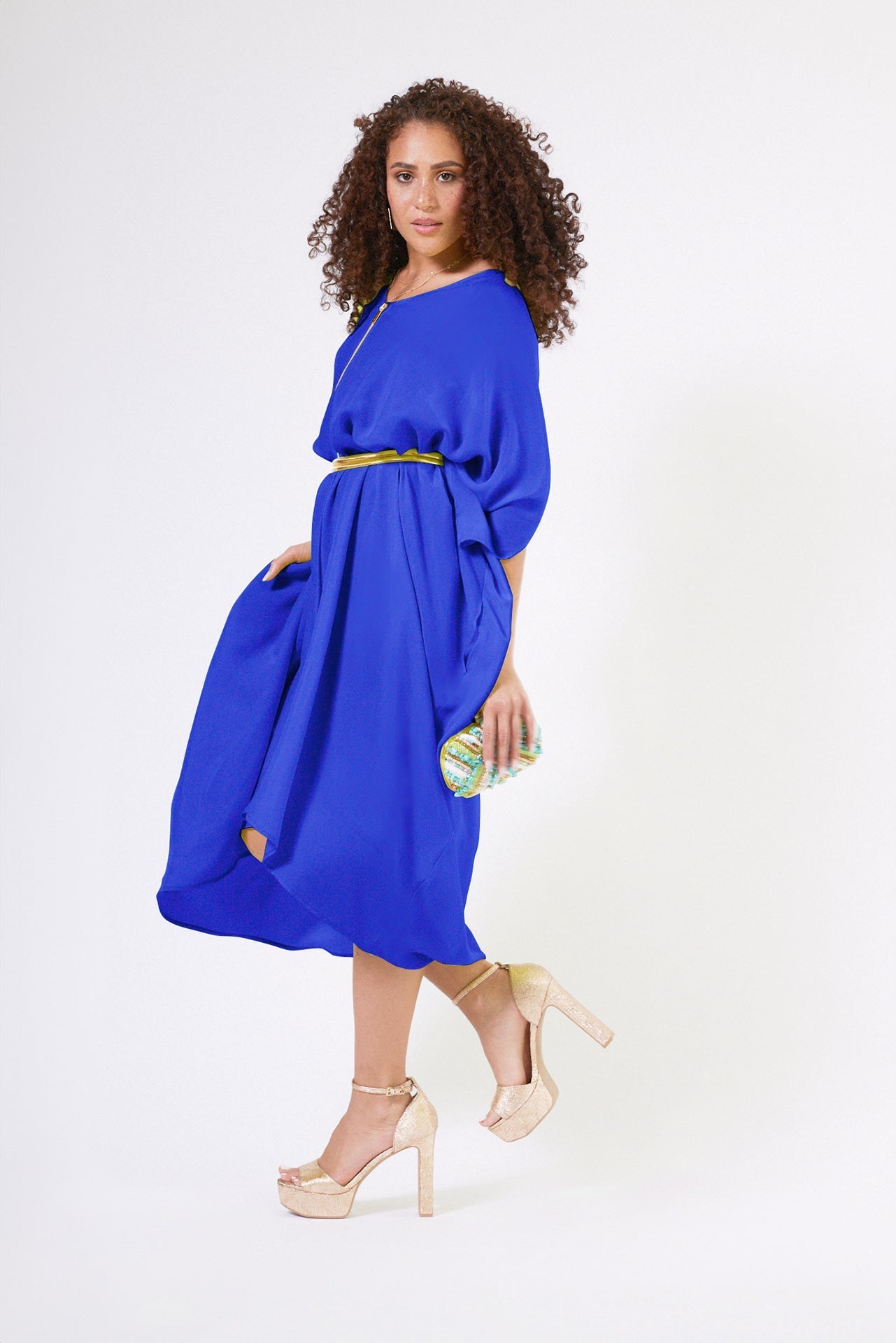 woman standing wearing a royal blue kaftan duster with front zipper made from recycled materials