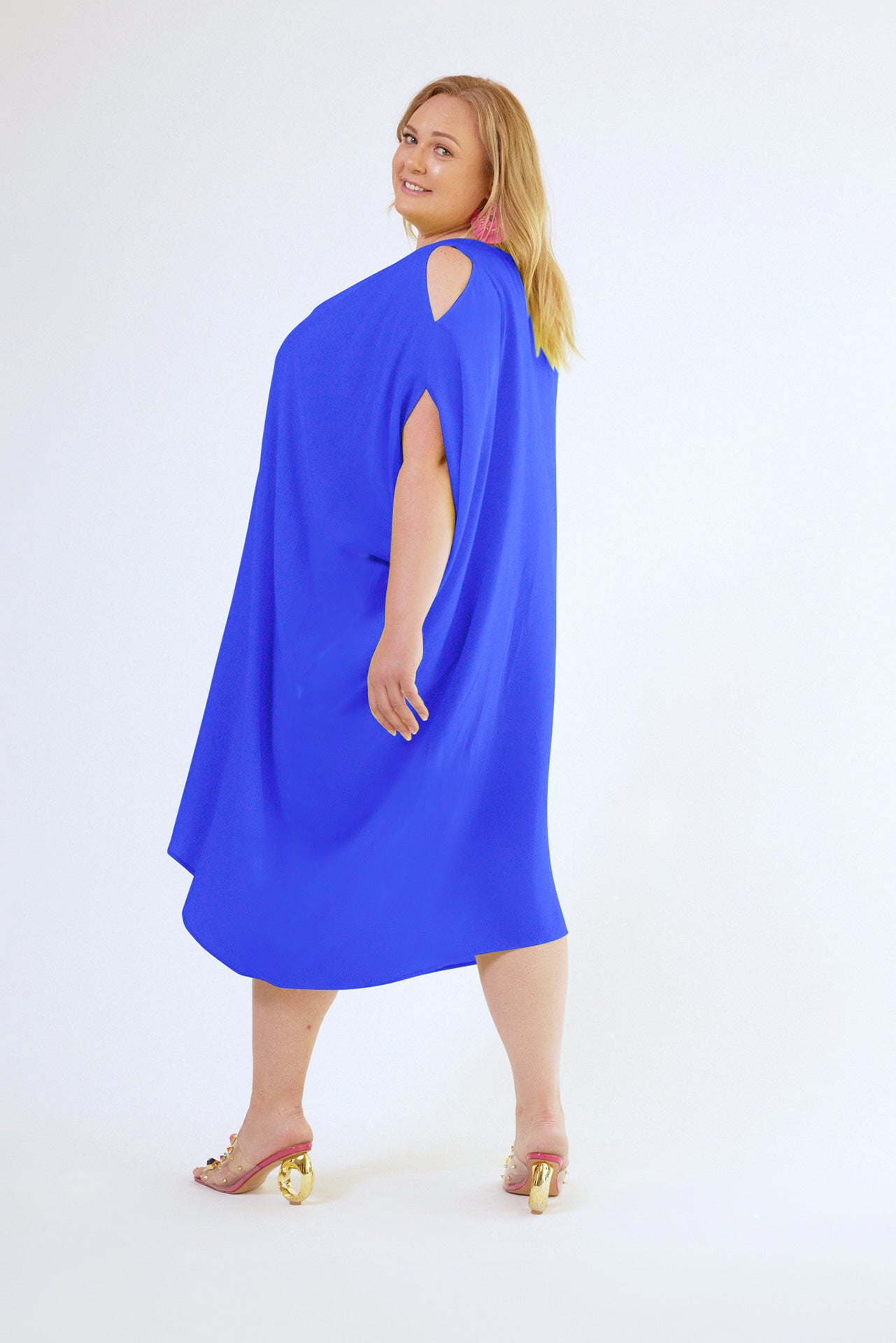 side view of woman modelling a royal blue kaftan duster with front zipper made from recycled materials