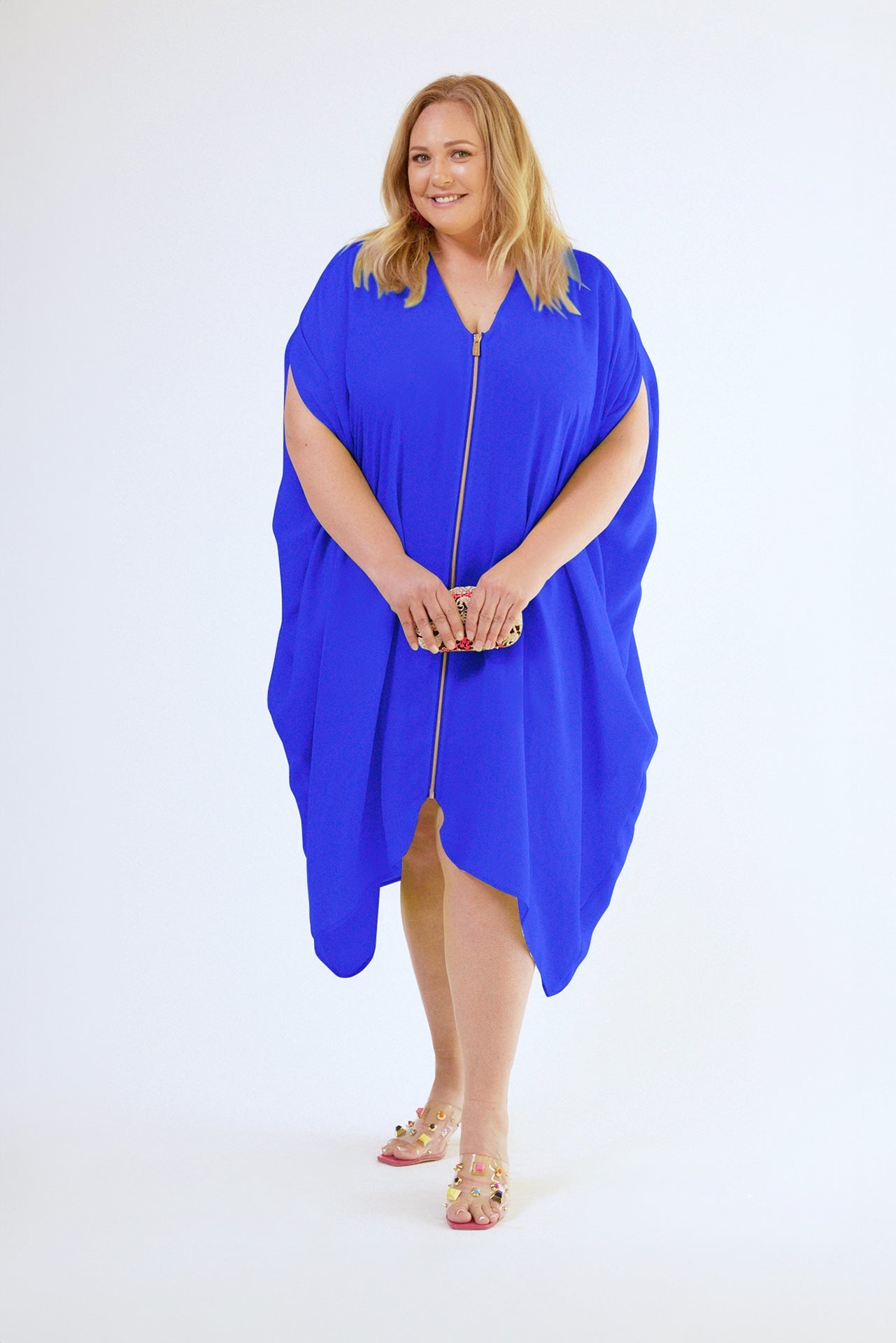 front view of woman modelling a royal blue kaftan duster with front zipper made from recycled materials