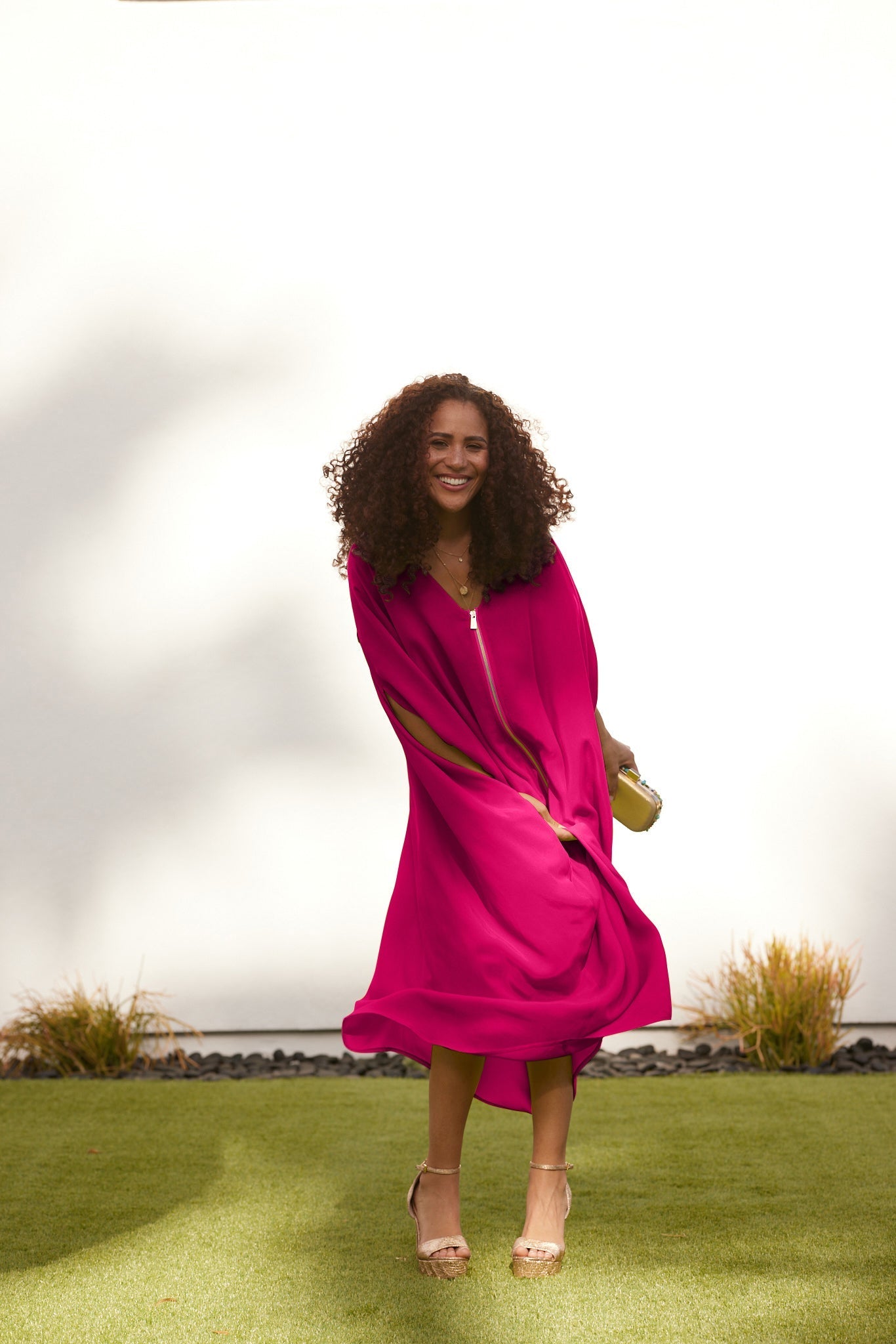 woman outside wearing magenta kaftan duster with front zipper made from recycled materials