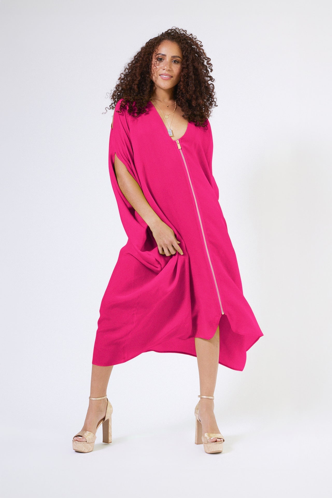 front profile view of woman wearing magenta kaftan duster with front zipper made from recycled materials 3