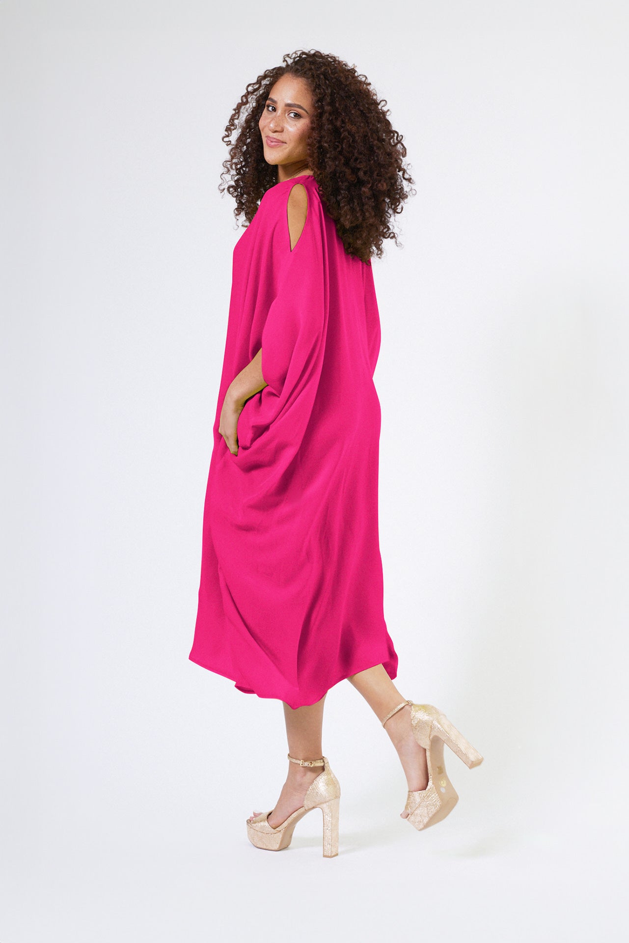 side profile view of woman wearing magenta kaftan duster with front zipper made from recycled materials