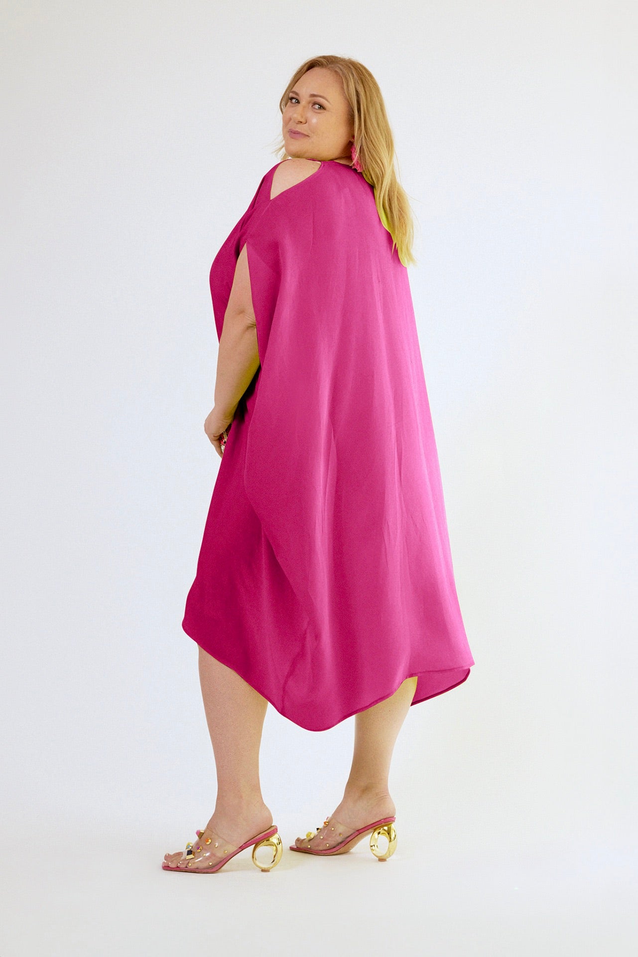 back profile view of woman wearing magenta kaftan duster with front zipper made from recycled materials