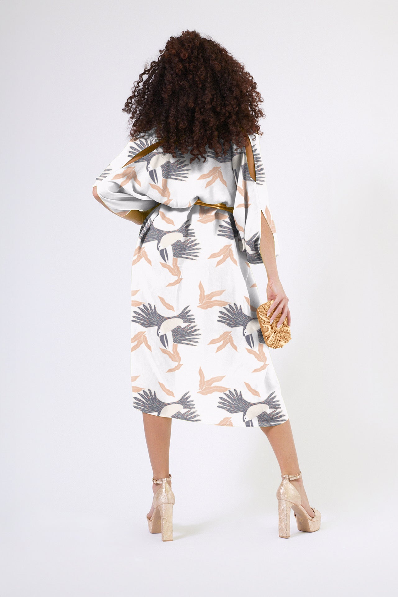 back profile of woman wearing grey yellow and white all over tropical print kaftan duster with zipper made from recycled materials 2