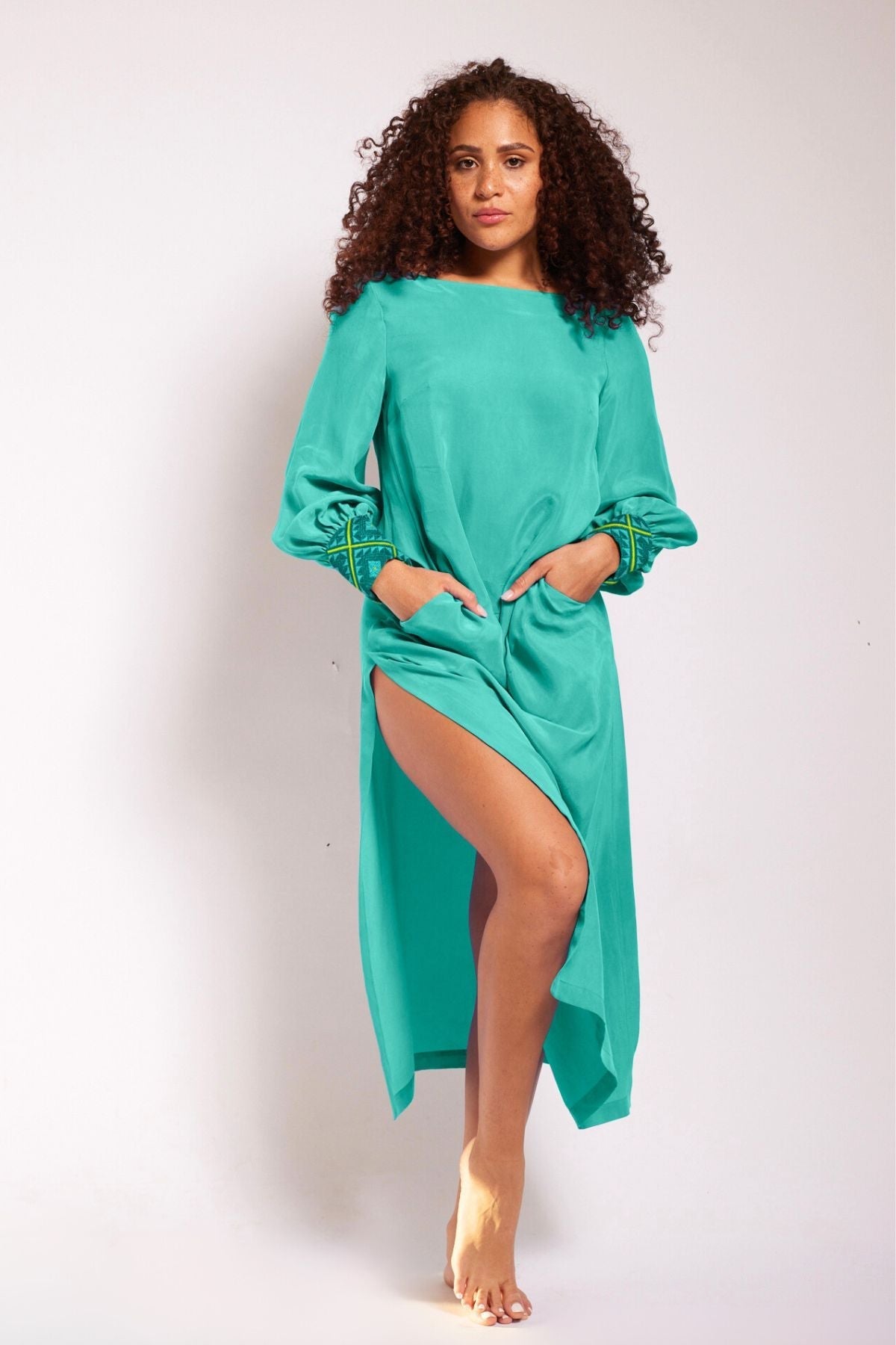 front view of woman wearing turquoise kaftan duster with embroidered sleeves made from recycled materials 3
