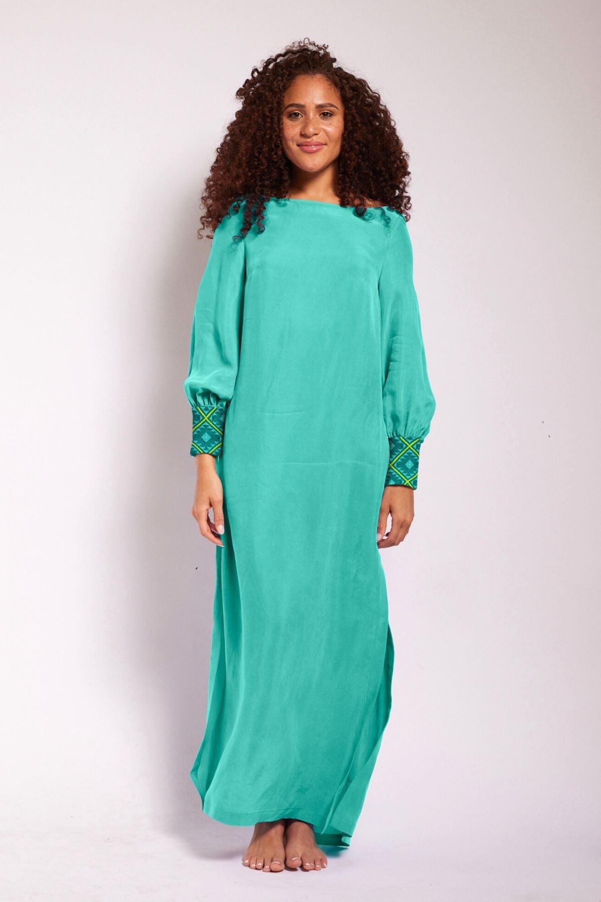 front view of woman wearing turquoise kaftan duster with embroidered sleeves made from recycled materials 4