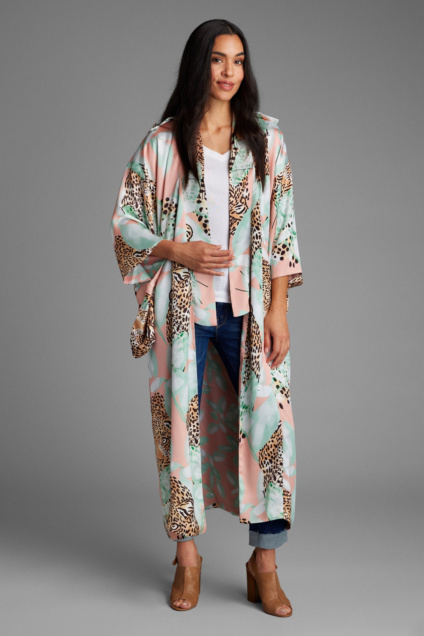 Woman standing wearing an all over tropical animal print kimono duster made from recycled textiles