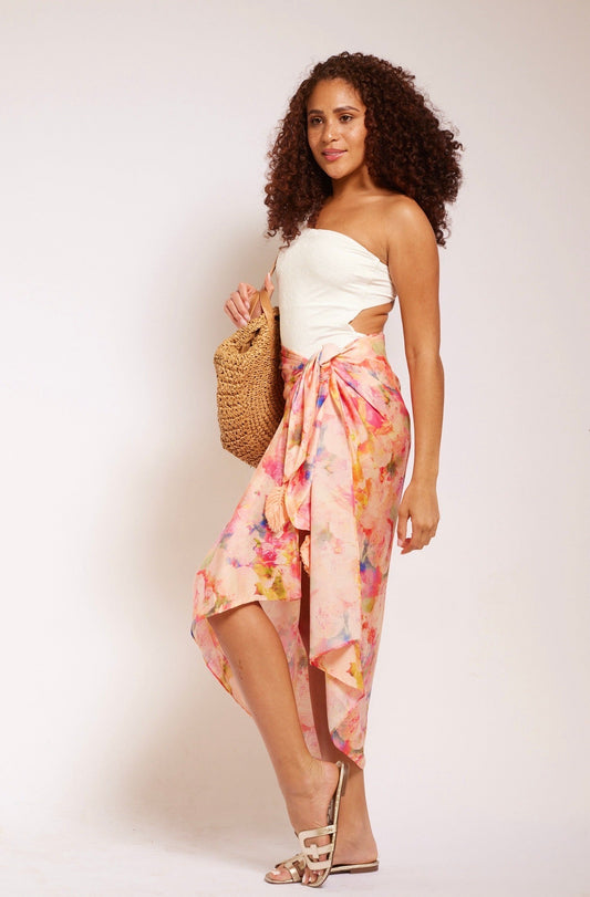 woman standing wearing all over peach floral sarong beachwear made from recycled materials