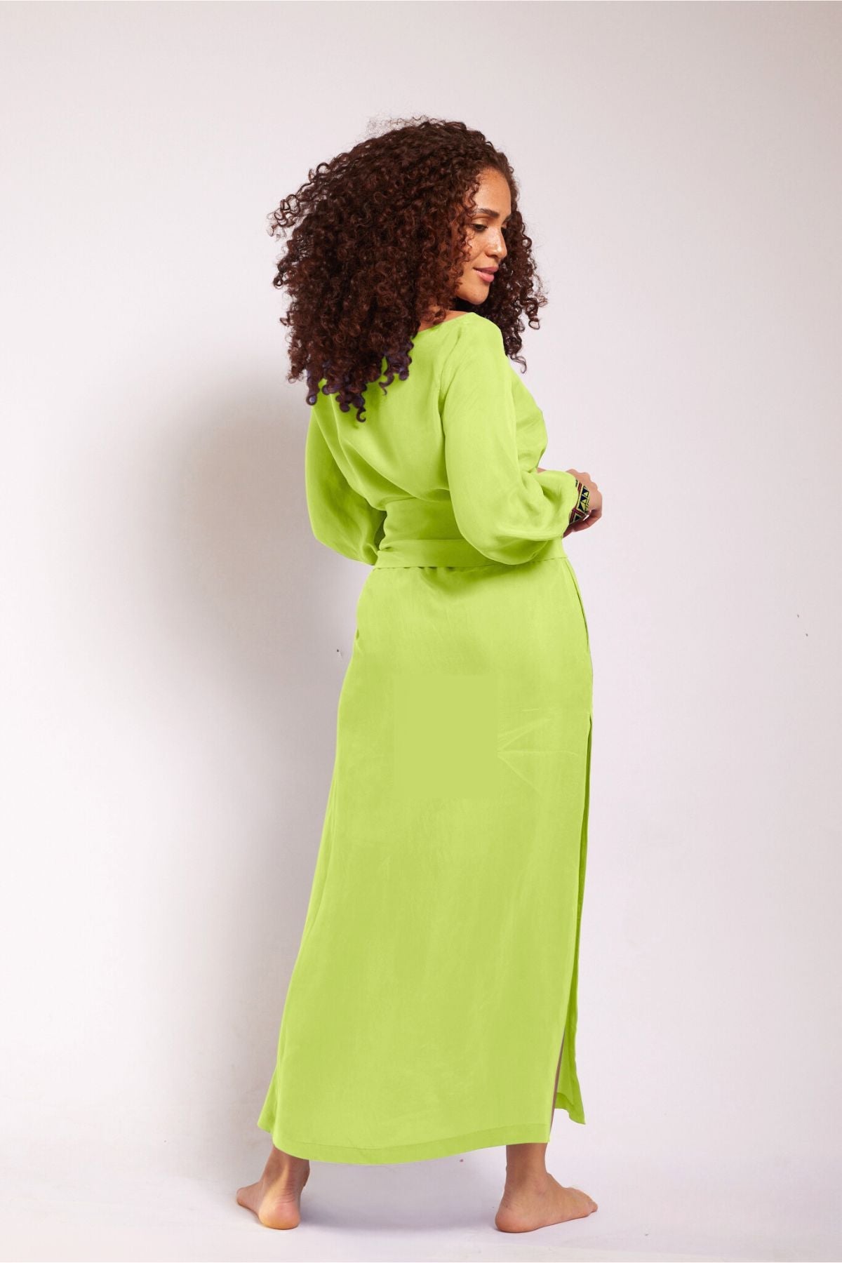 side view of woman modelling a bright yellow kaftan duster with embroidered sleeves made from recycled materials 3