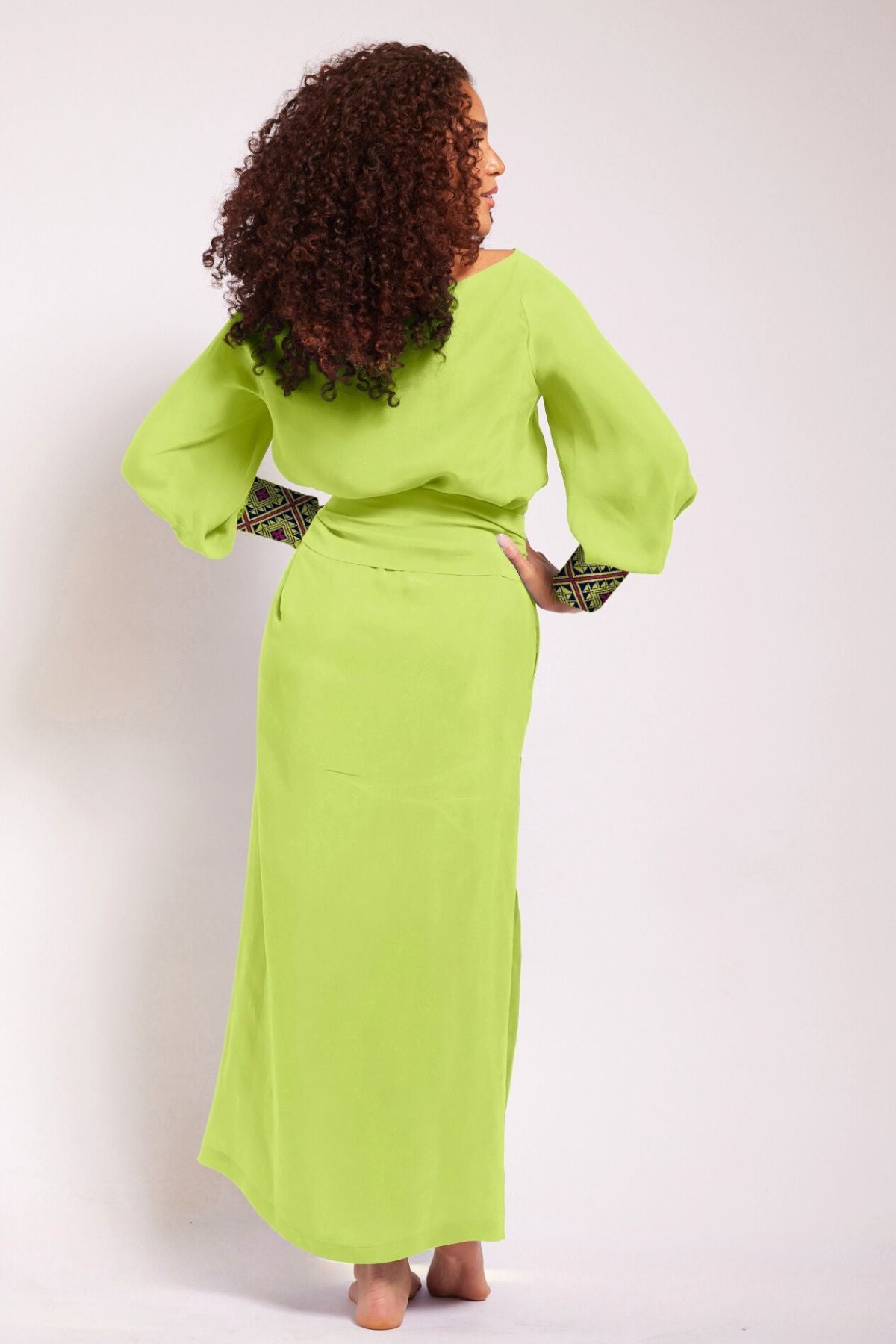 back view of woman modelling a bright yellow kaftan duster with embroidered sleeves made from recycled materials 6