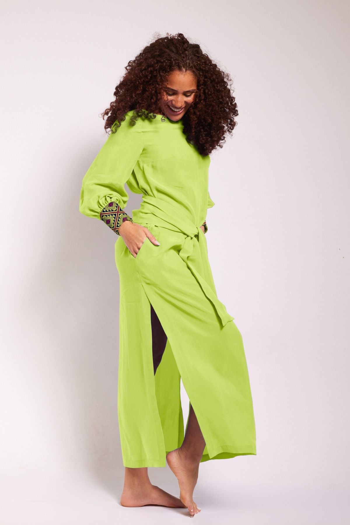side view of woman modelling a bright yellow kaftan duster with embroidered sleeves made from recycled materials 2